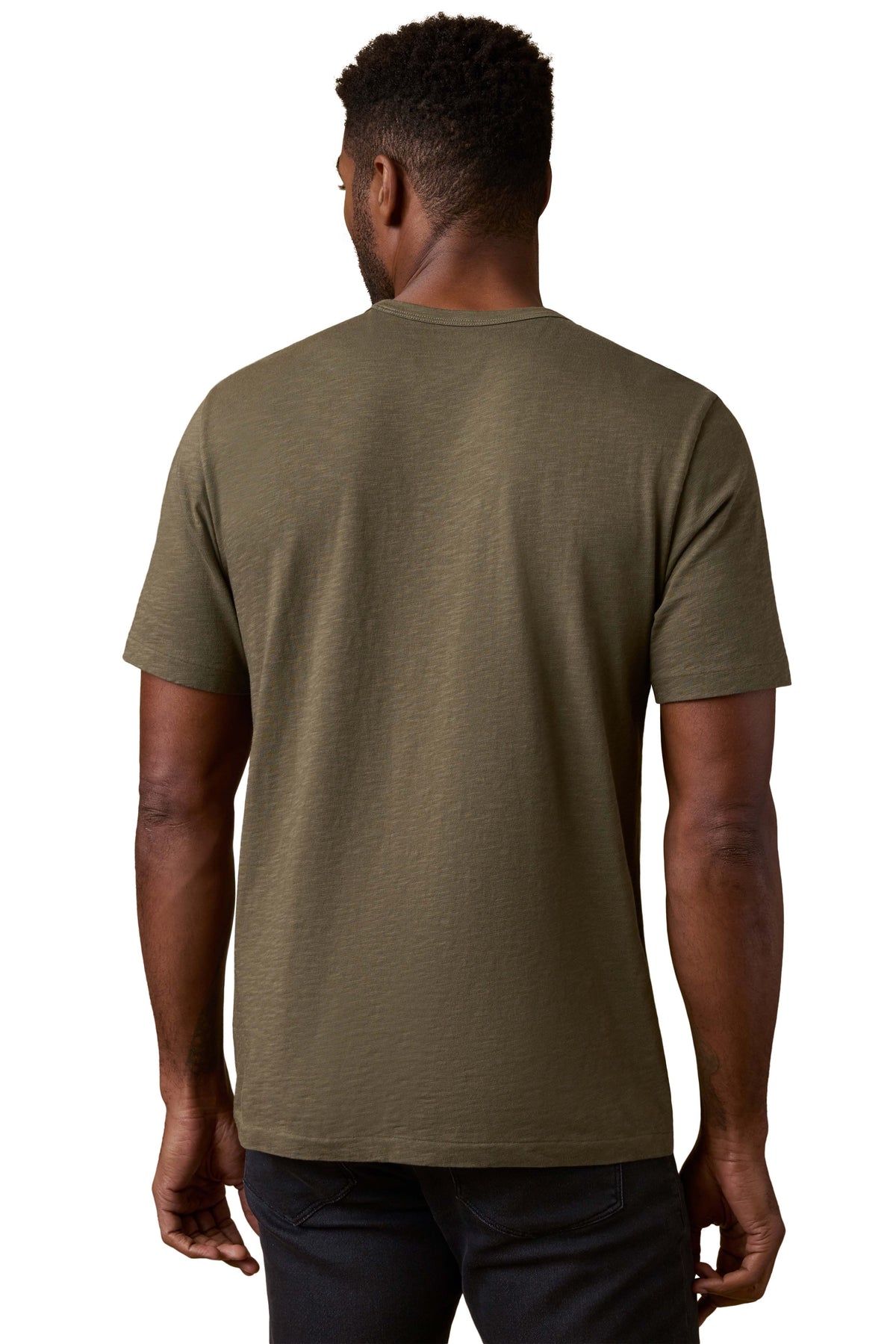 A man viewed from behind wearing a green tee and black jeans, image 3 of 3