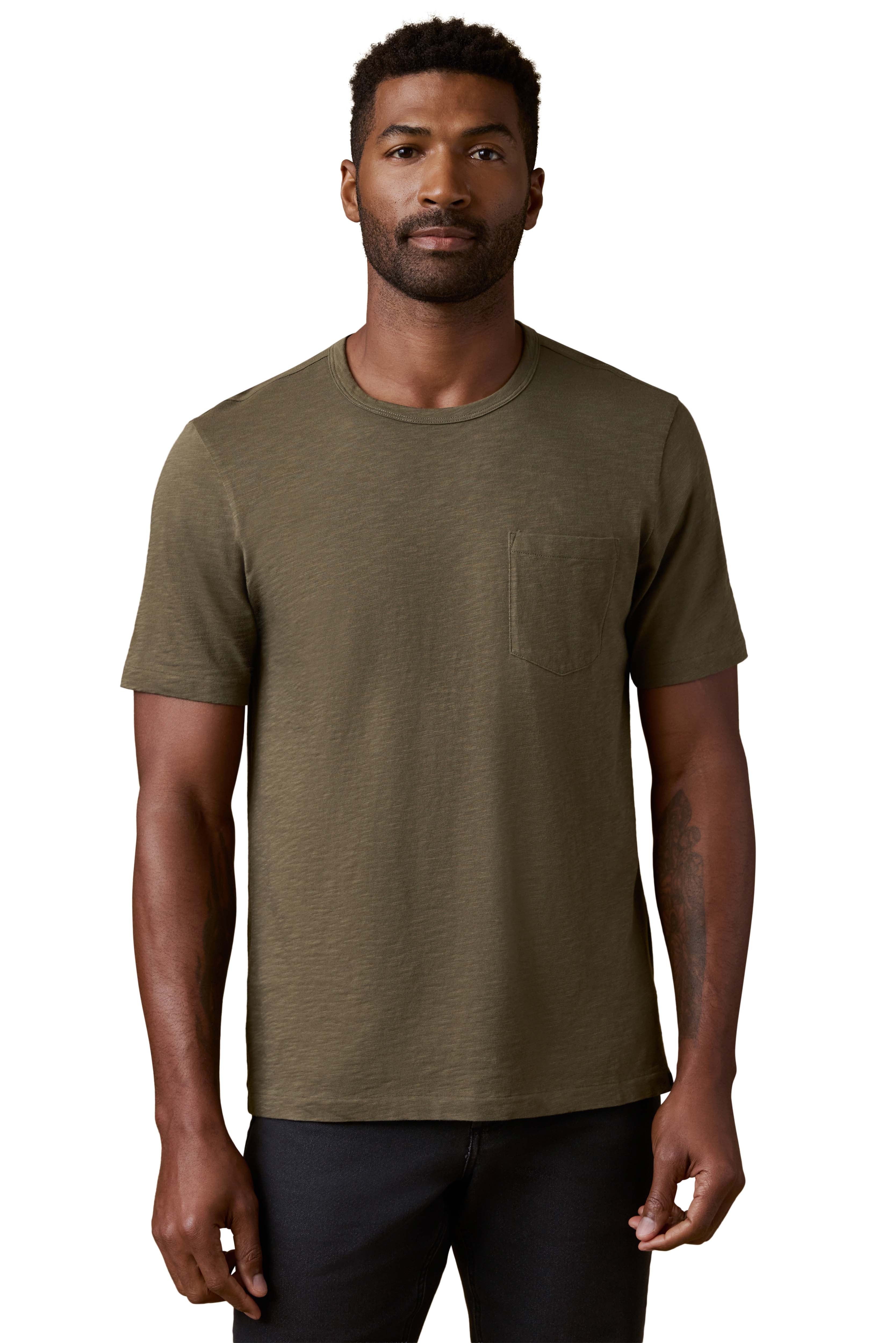 A man wearing a green tee and black jeans