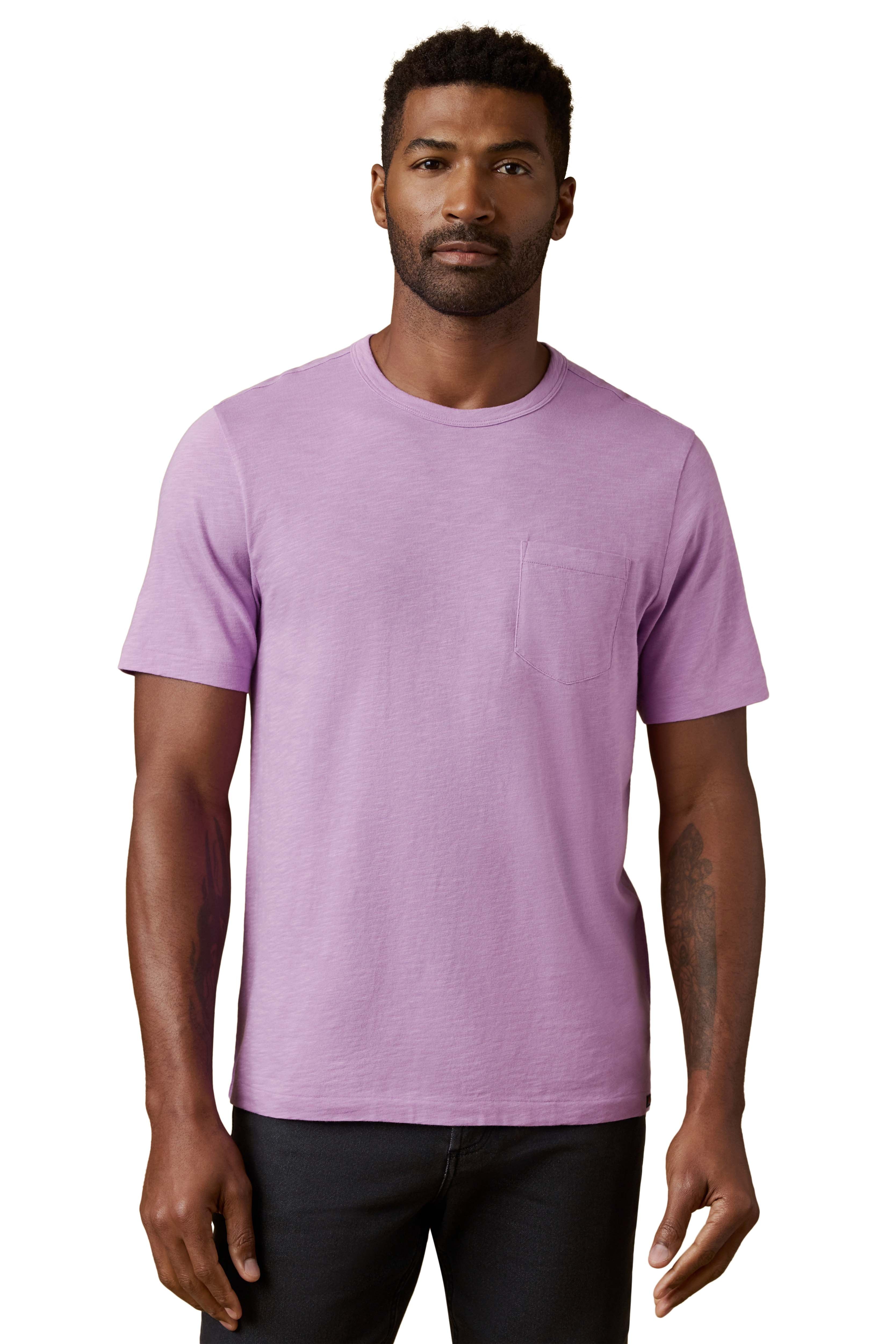 A man wearing a purple tee and black jeans