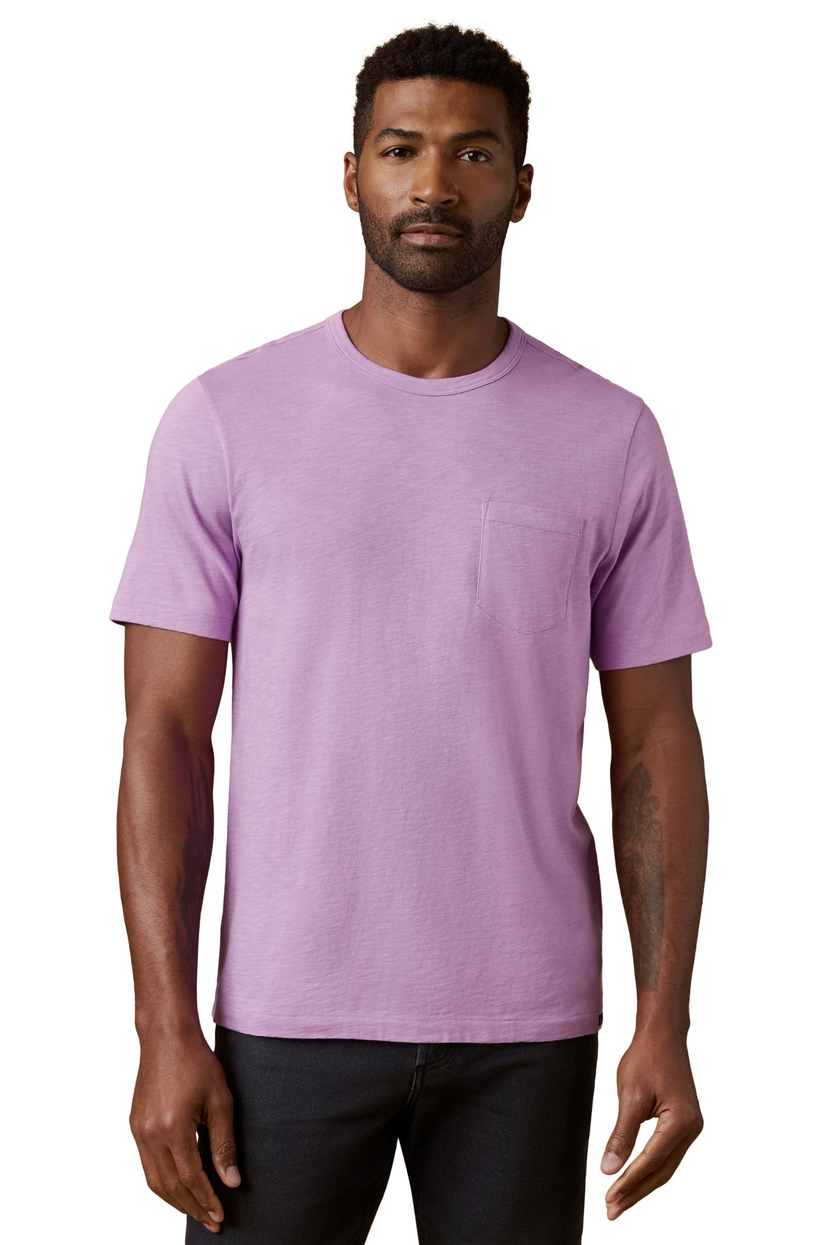 A man wearing a purple tee and black jeans, image 1 of 3
