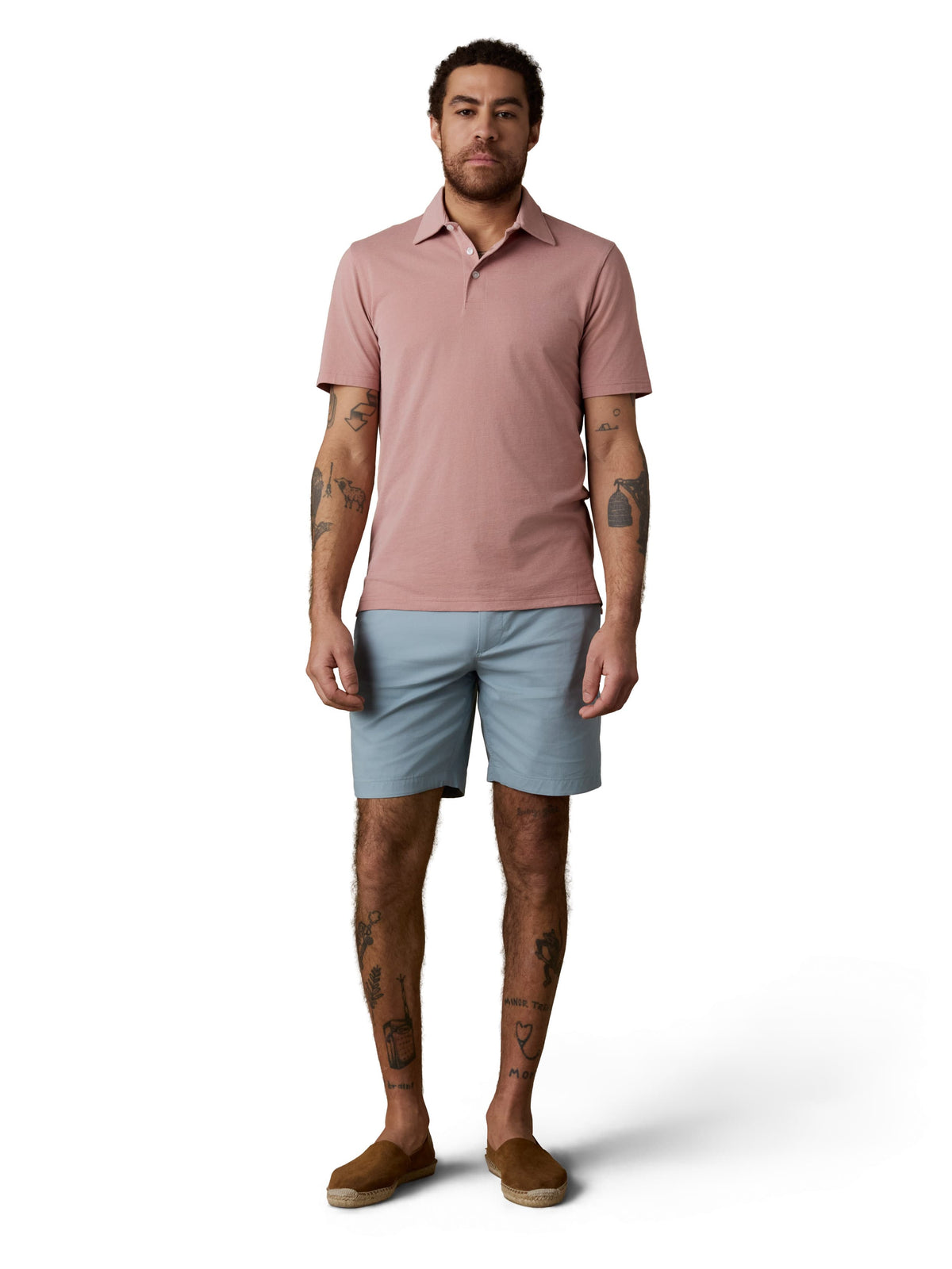 A man wearing a pink polo, light blue shorts, and brown shoes, image 2 of 3