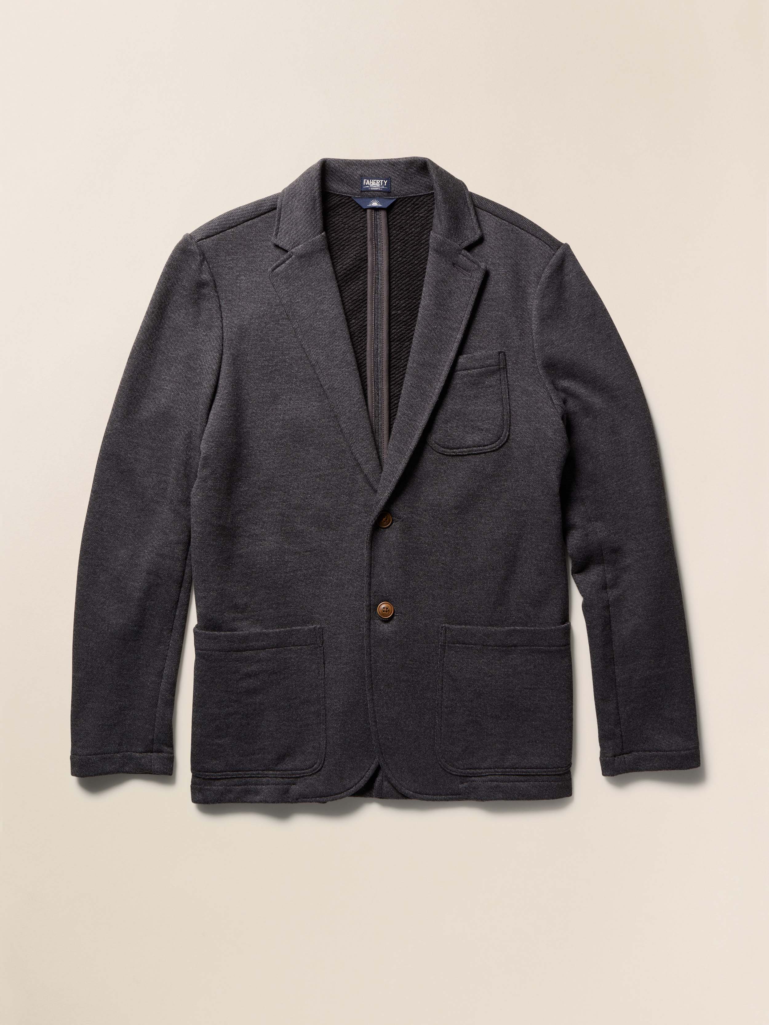 Dark gray blazer with a button on a beige background