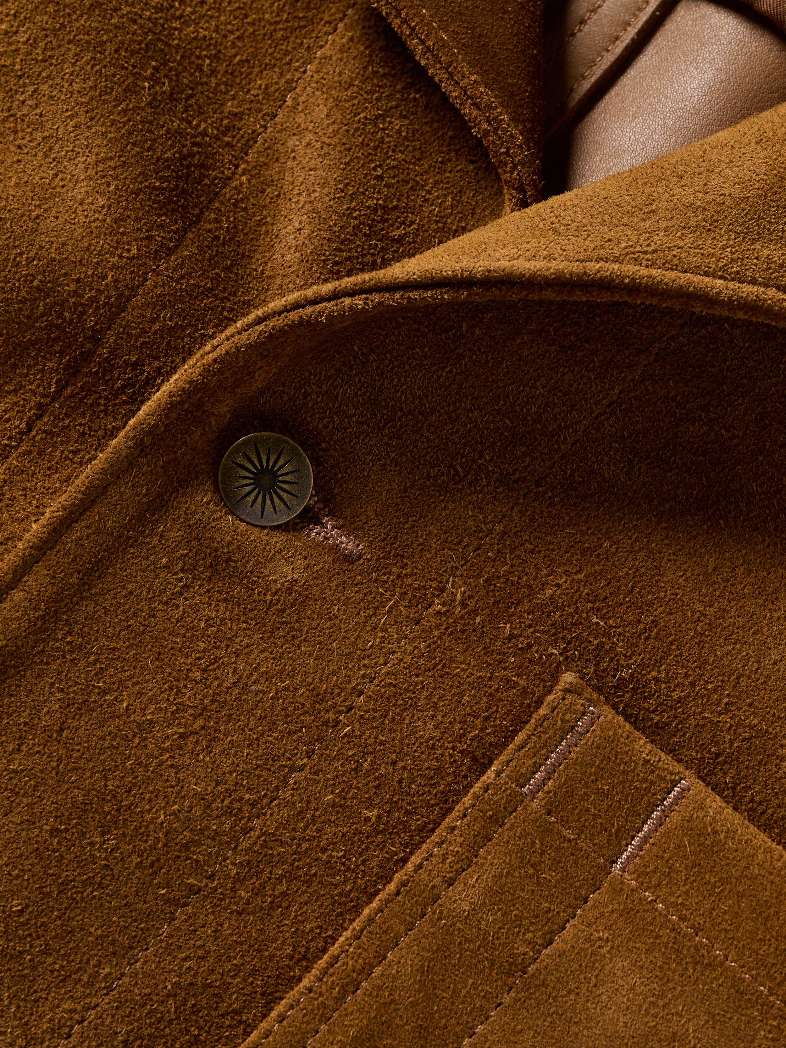 Close-up of a brown suede jacket with a button