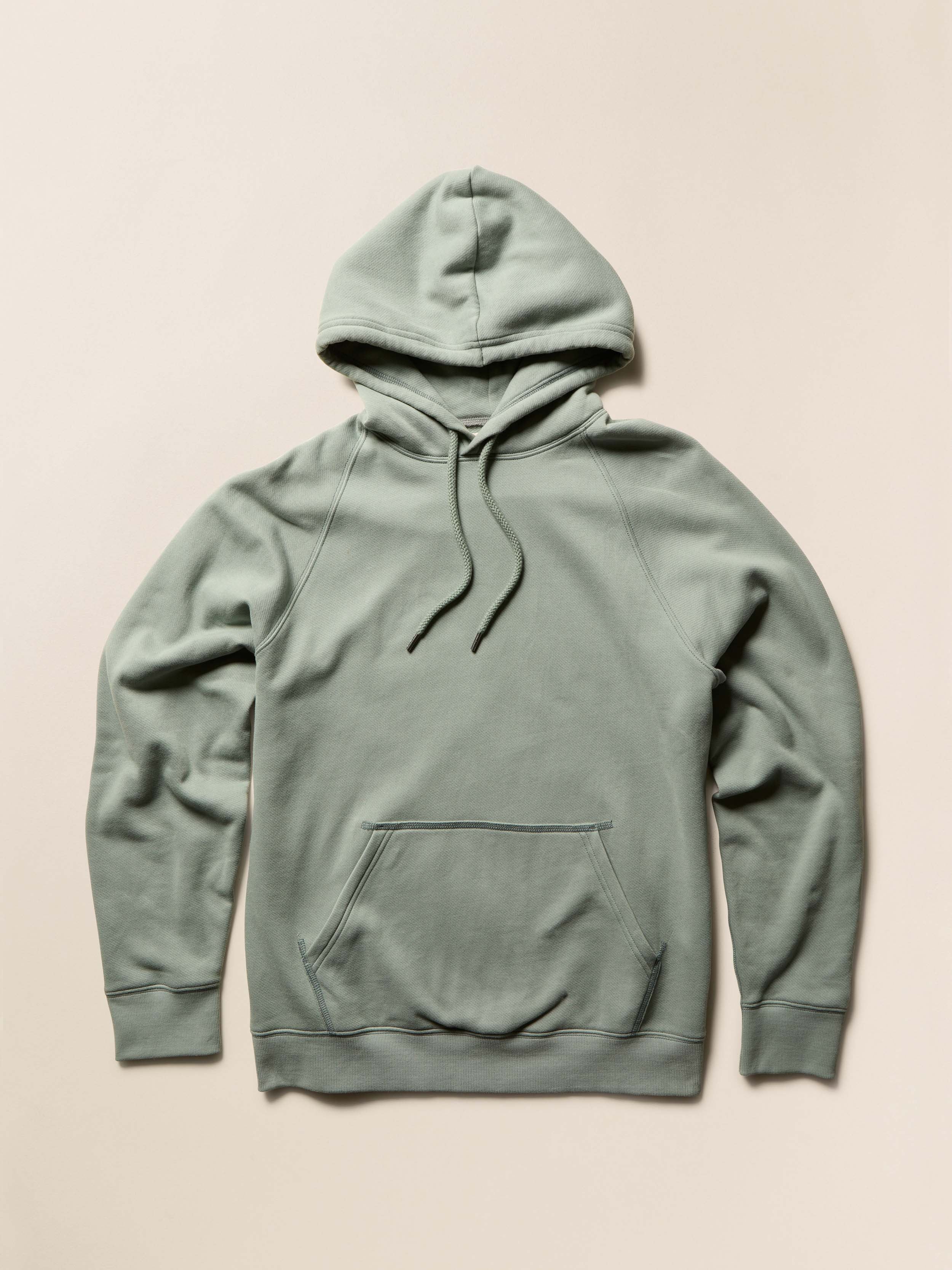 Green hoodie on a beige background