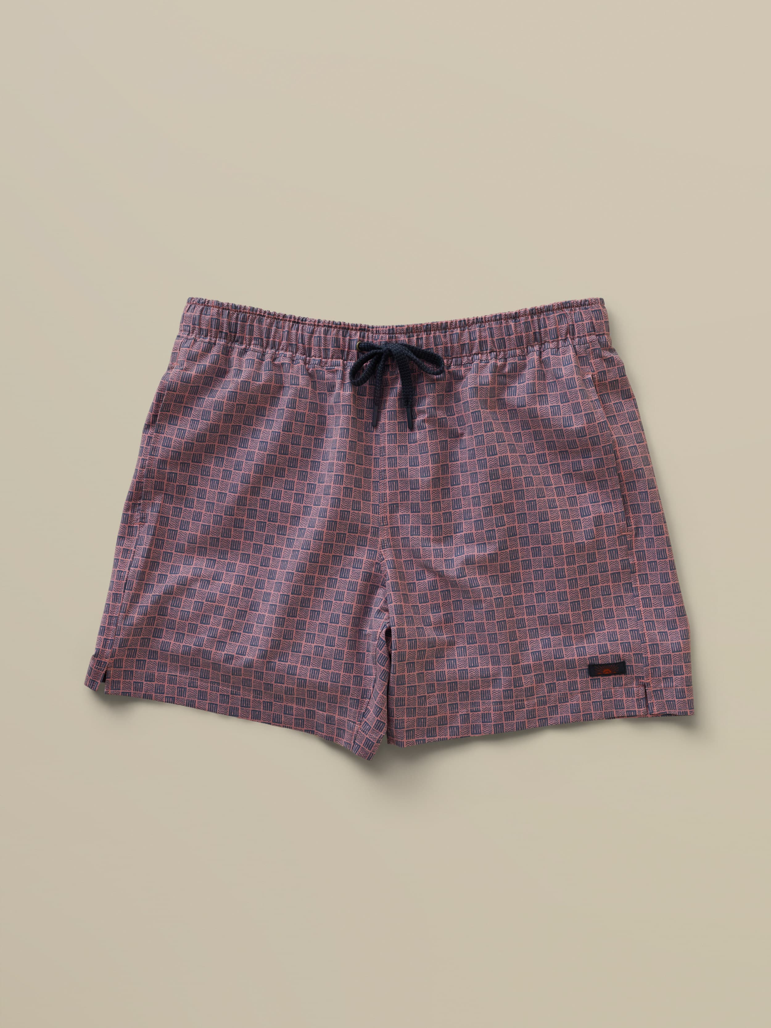 Patterned swim trunks with a drawstring on a beige background
