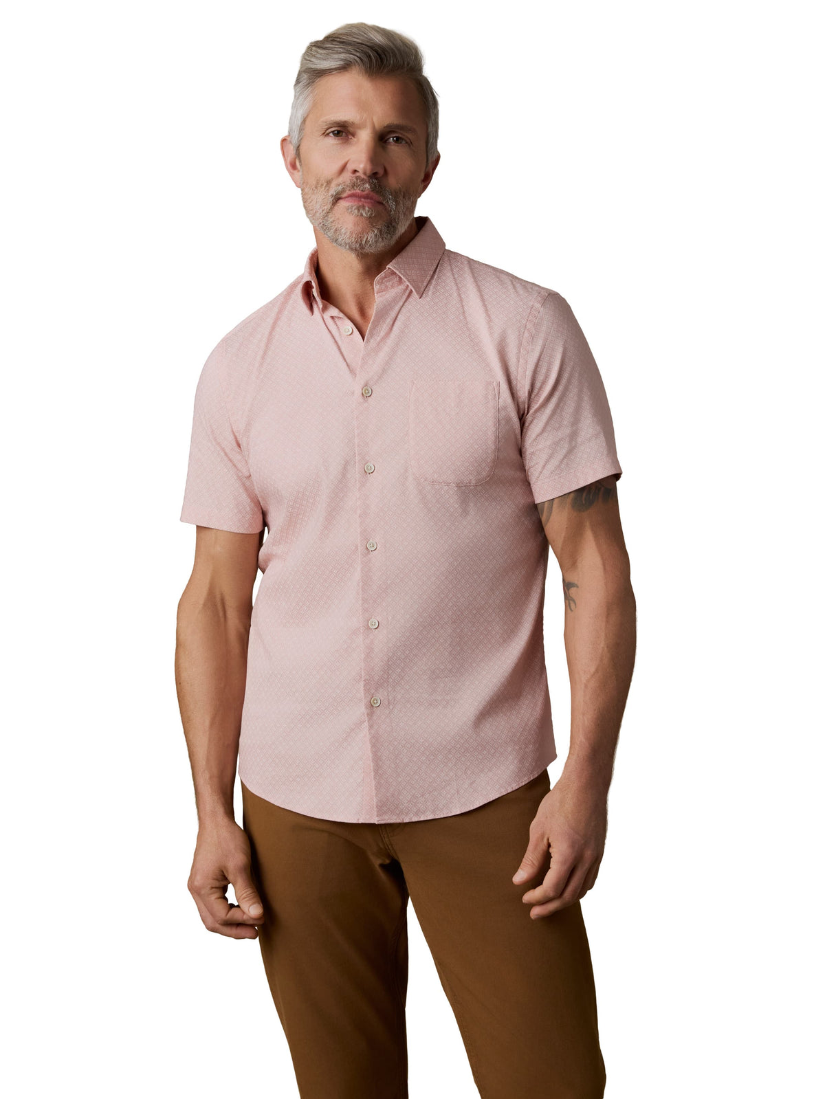 A man wearing a pink button up shirt and brown pants, image 1 of 3