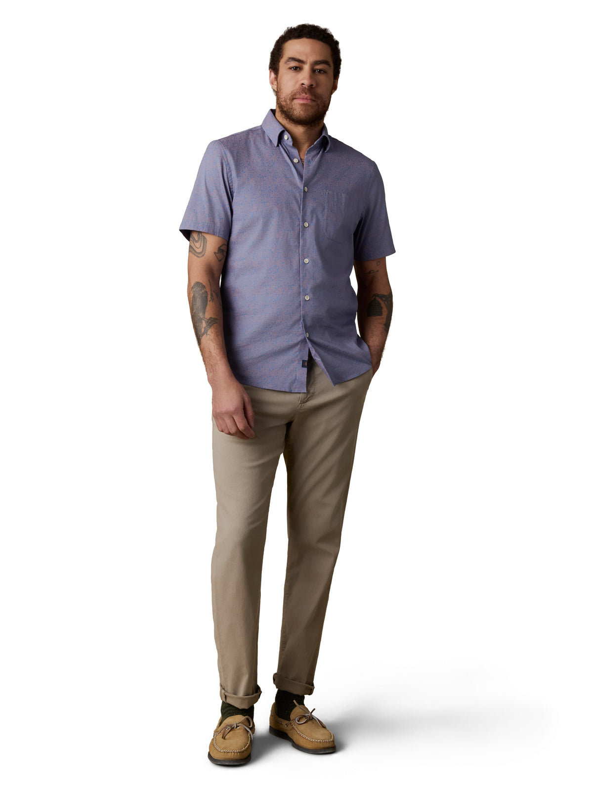 A man wearing a blue button up shirt, beige pants, and boat shoes, image 2 of 3