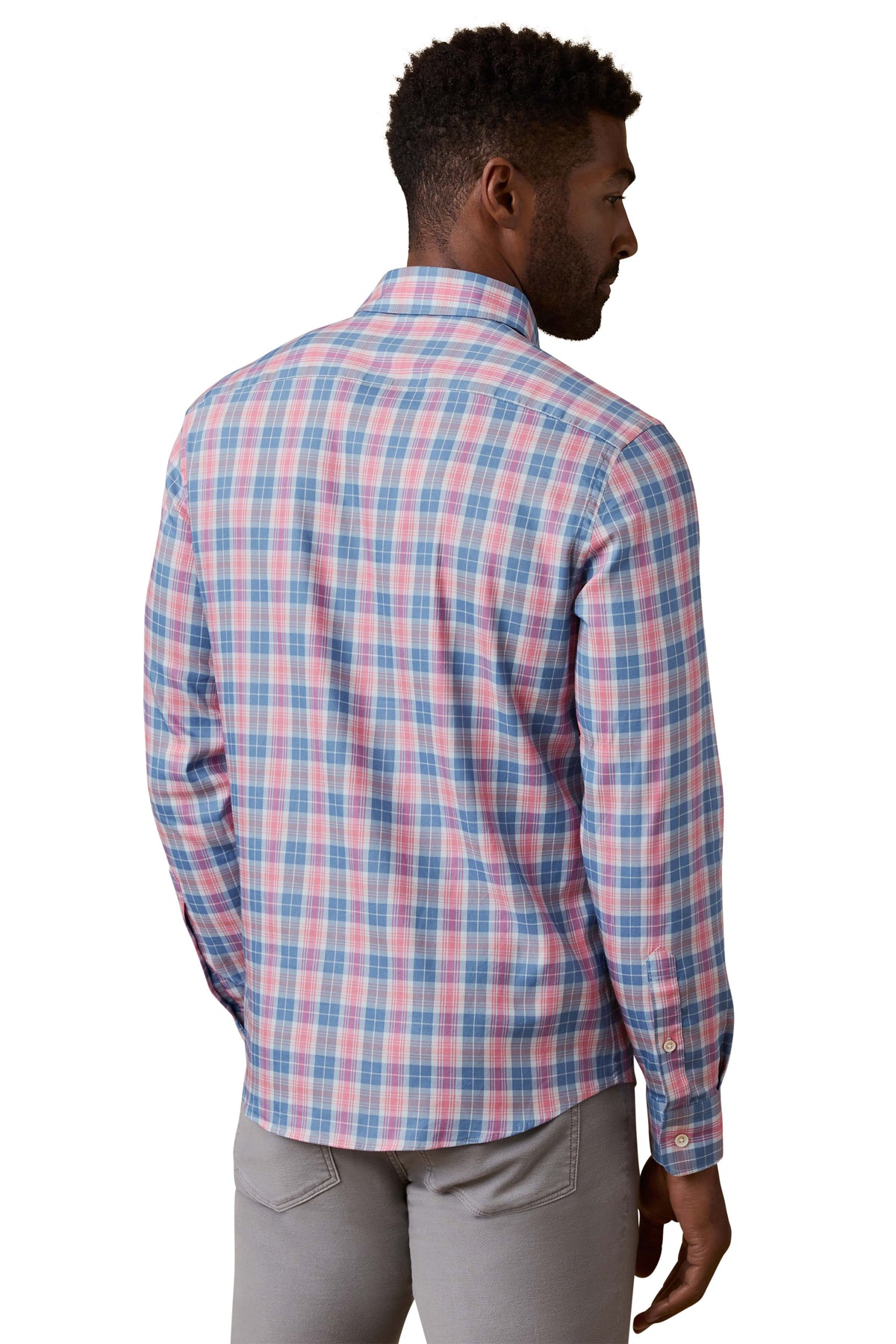 A man viewed from behind wearing a red and blue plaid shirt and grey pants, image 3 of 3