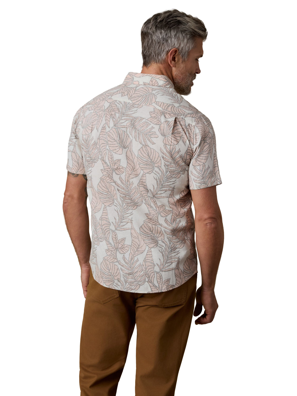 A man viewed from behind wearing a printed shirt and brown pants, image 3 of 3