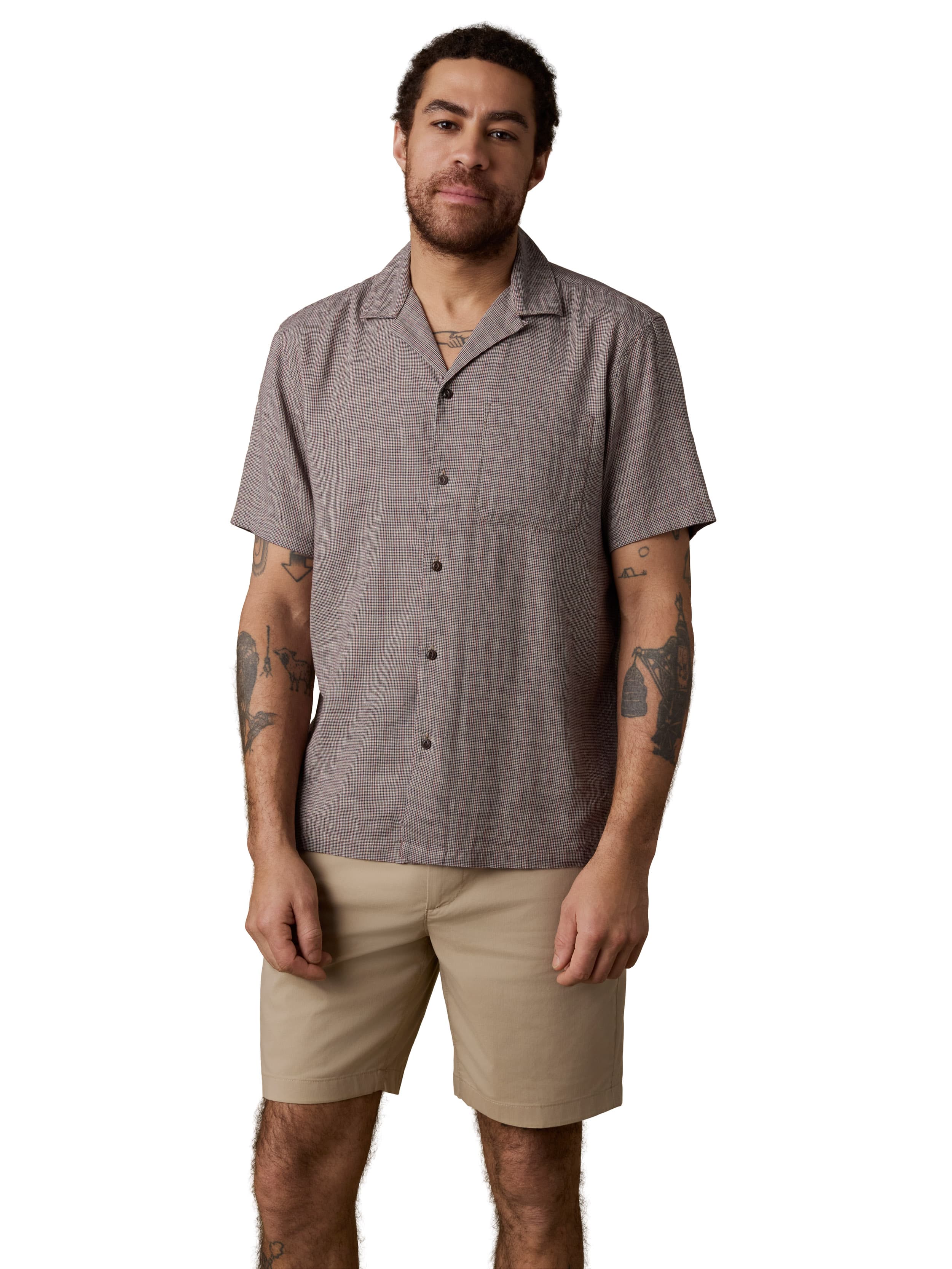 A man wearing a grey shirt and beige shorts
