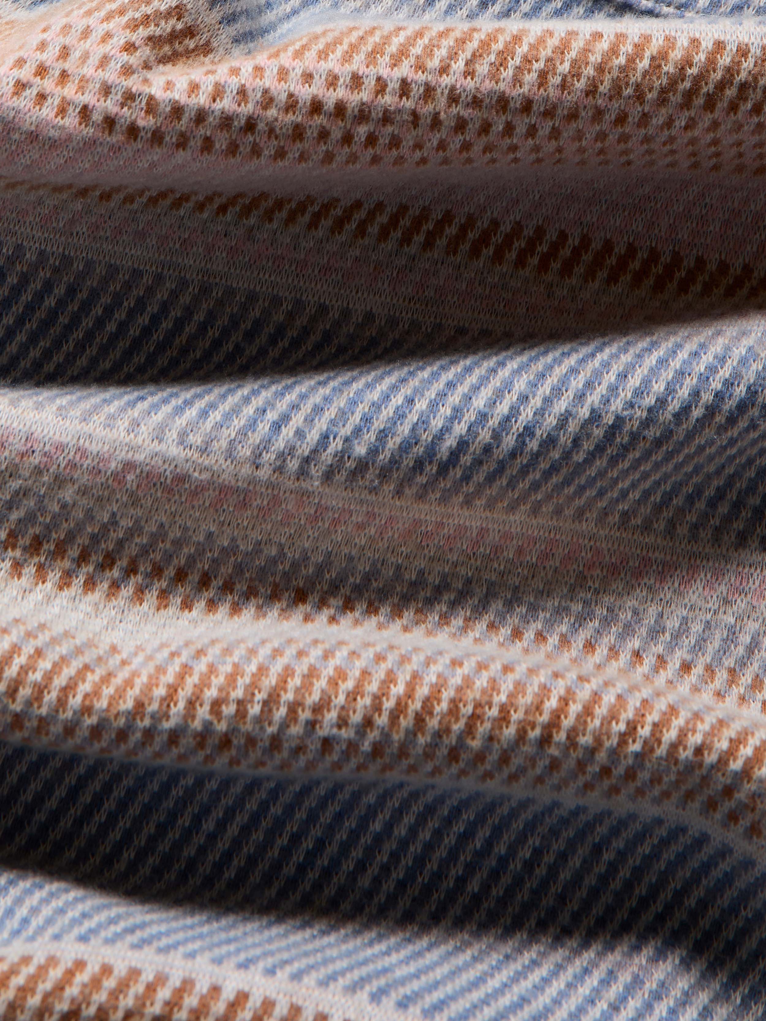 Close-up of a textured fabric with blue, brown, and beige colors.