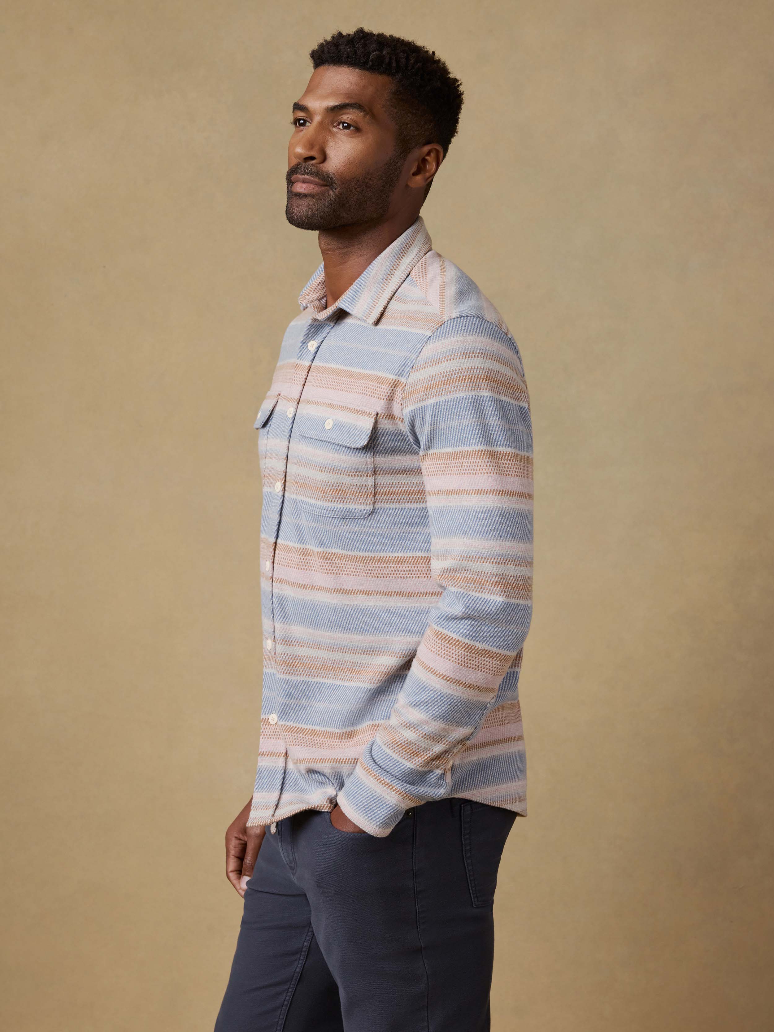 Man wearing a striped shirt against a beige background