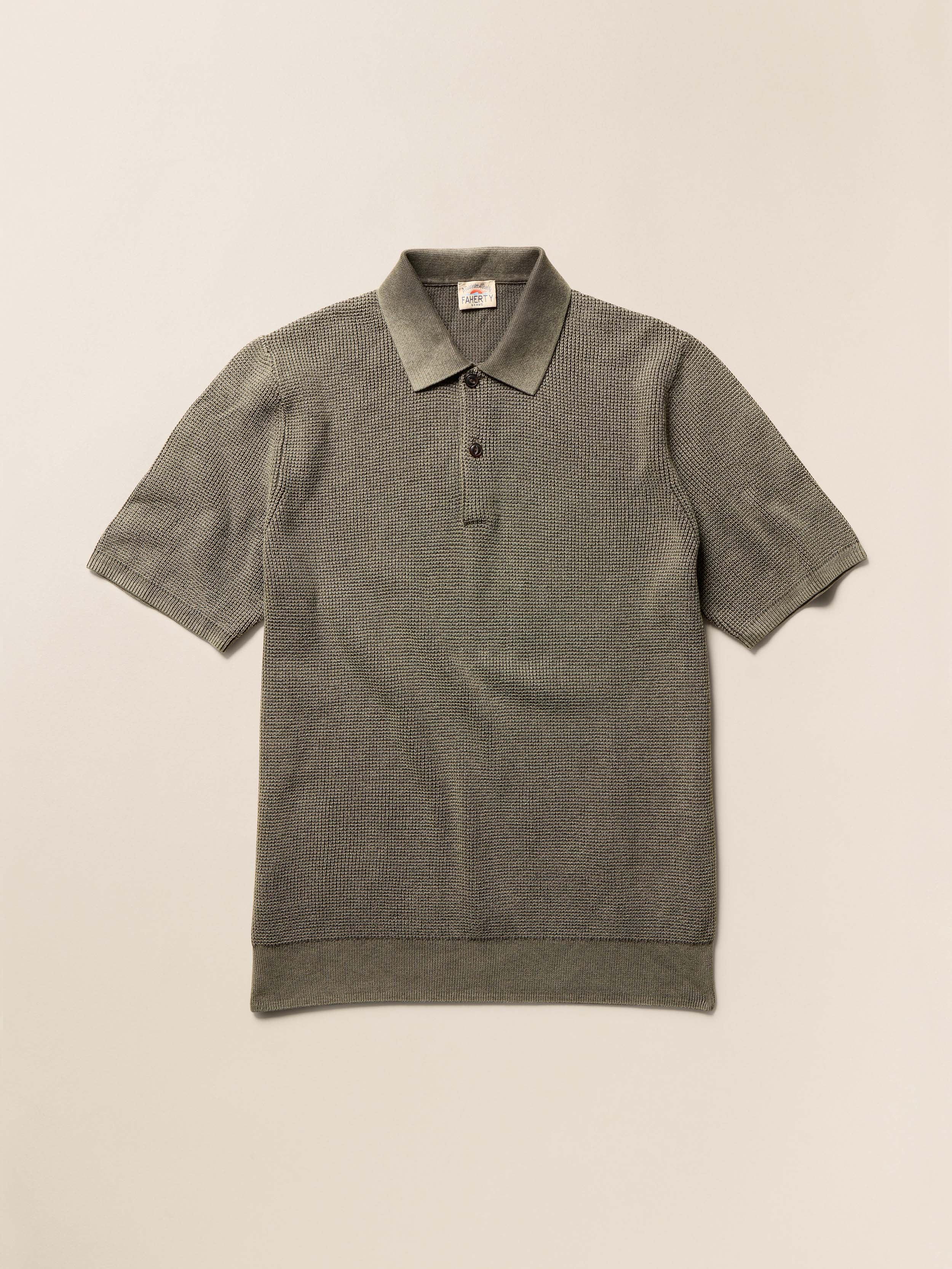 Green polo shirt on a beige background