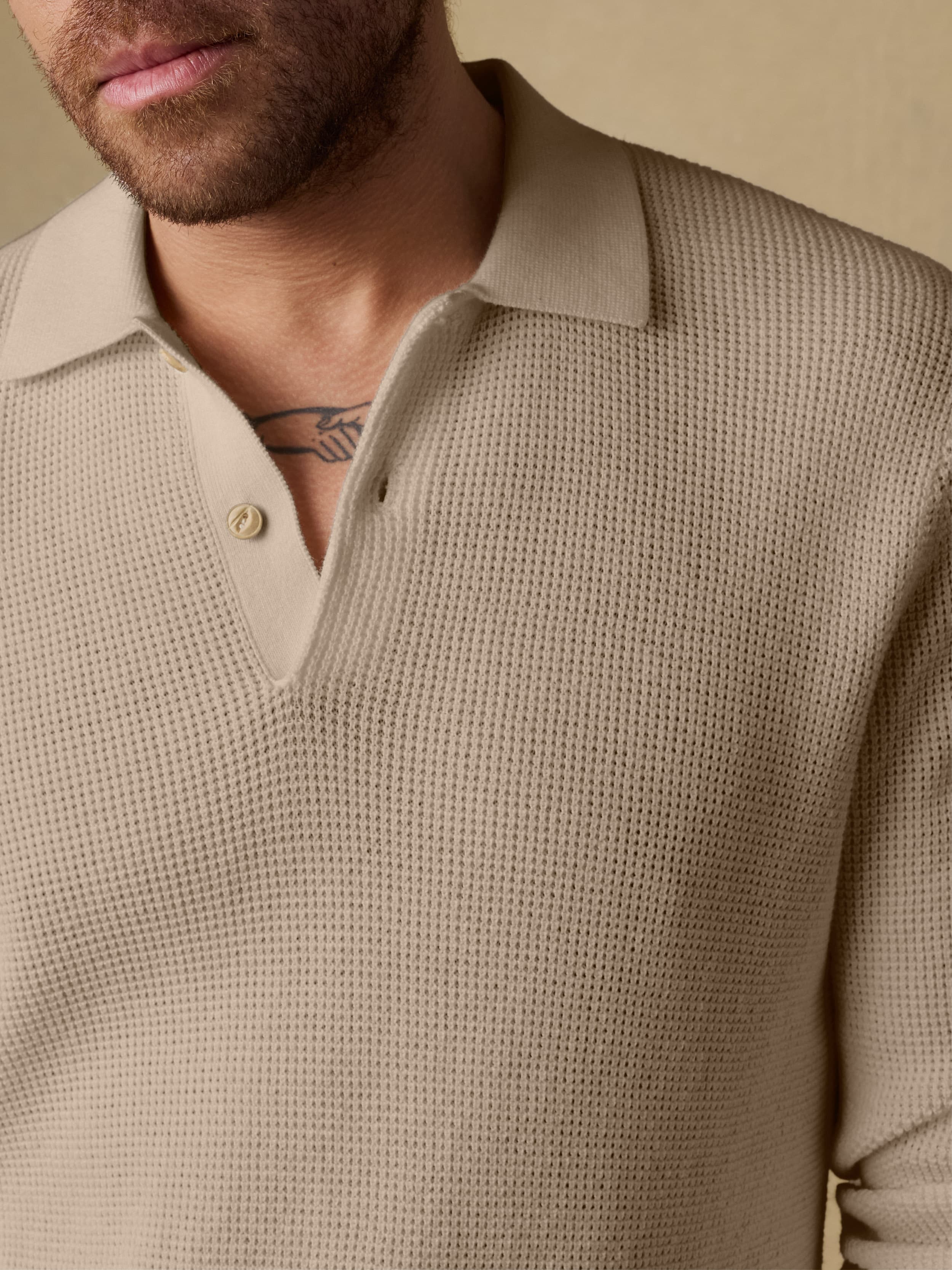 Man wearing a beige sweater against a beige background