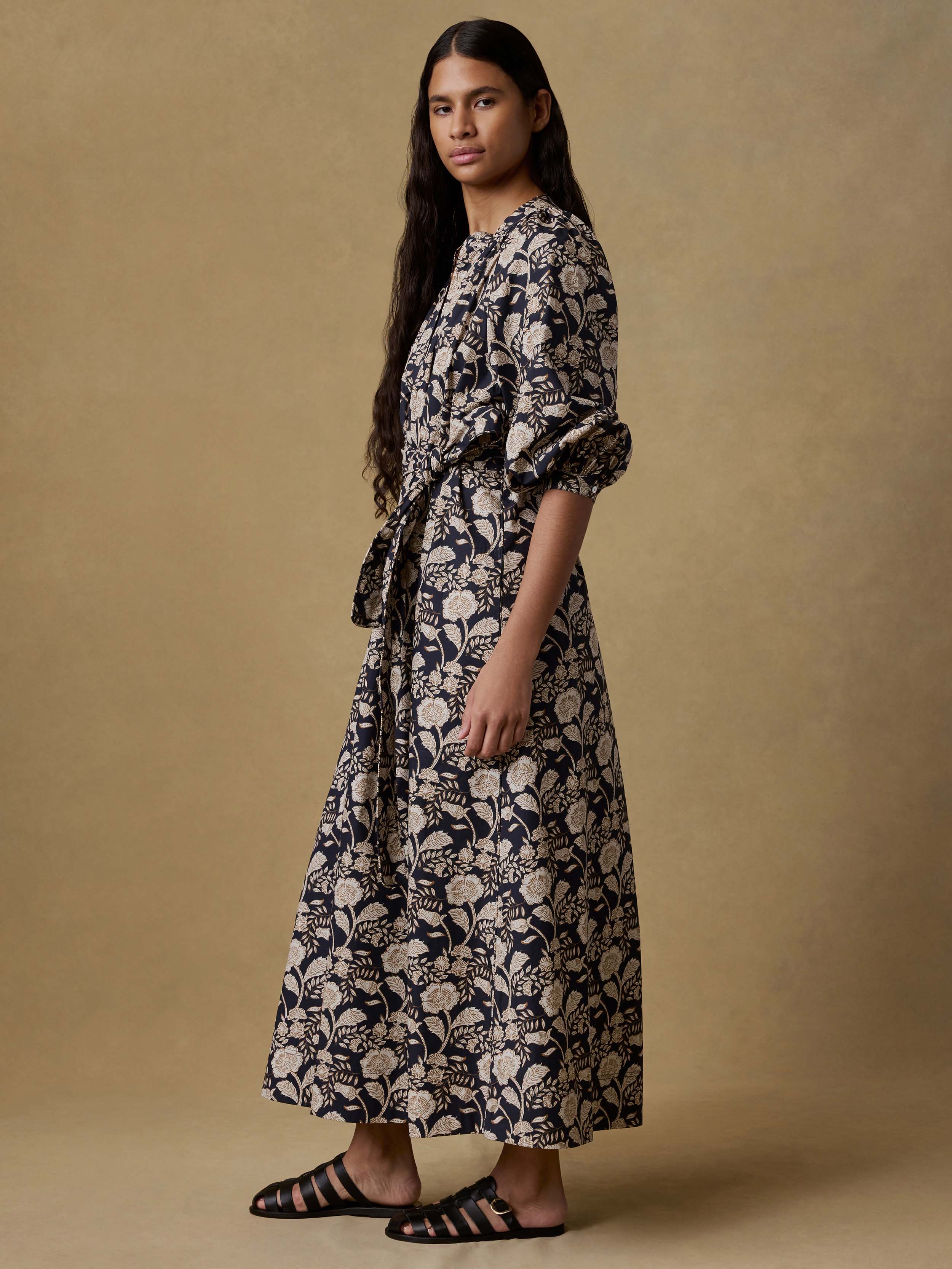 Woman wearing a floral dress against a beige background
