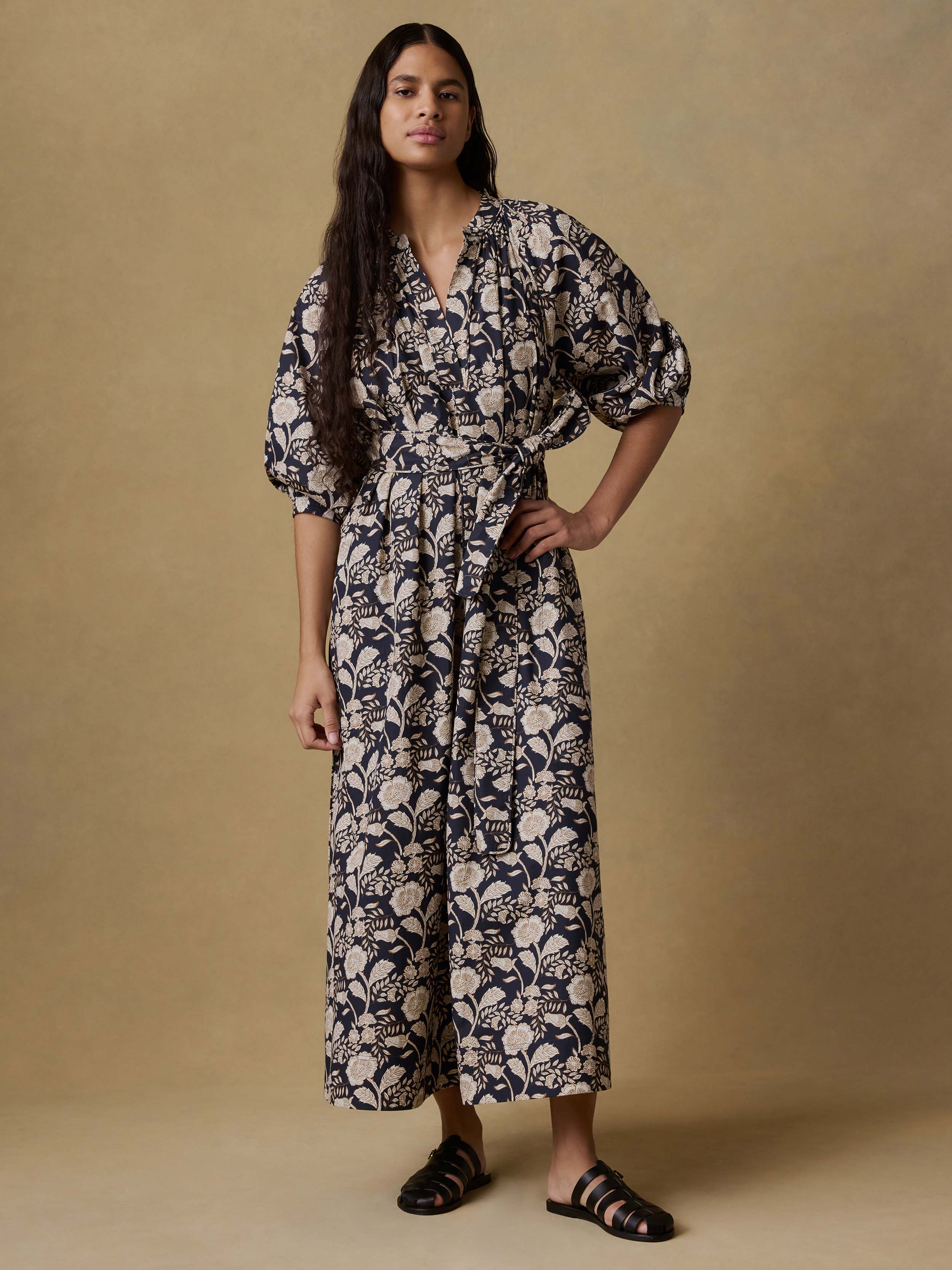 Woman wearing a floral dress against a beige background