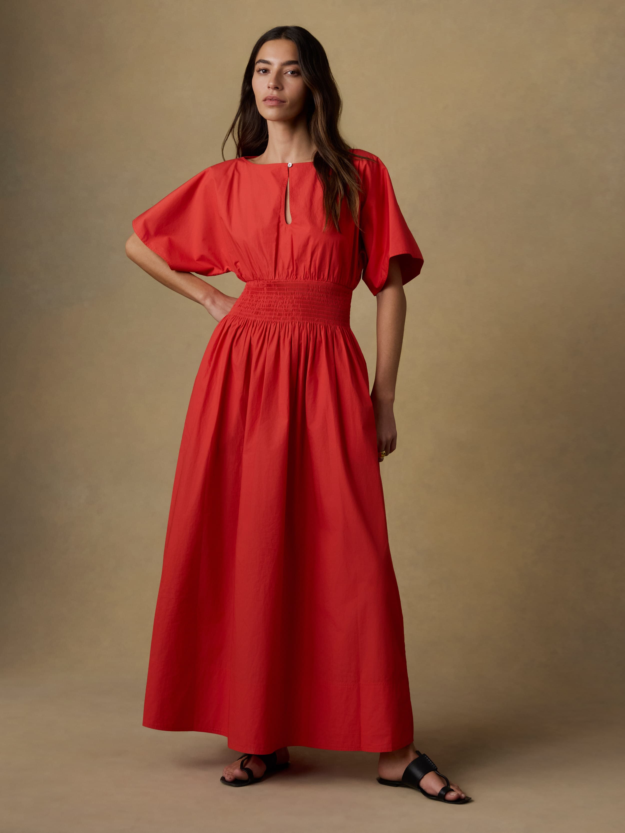 Woman wearing a red dress against a beige background