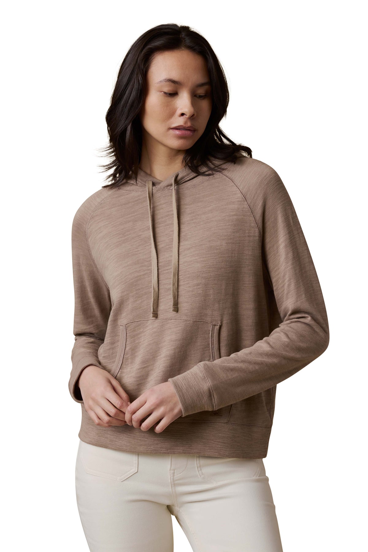 A woman wearing a beige hoodie and white pants, image 1 of 3