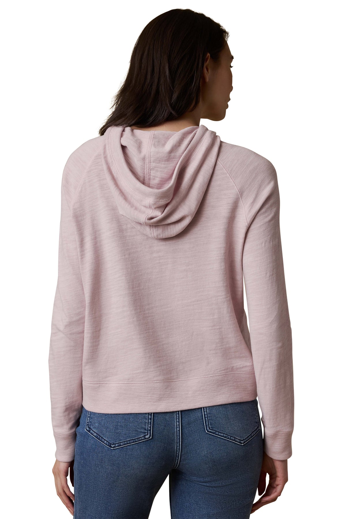 A woman viewed from behind wearing a light purple hoodie and blue jeans, image 3 of 3