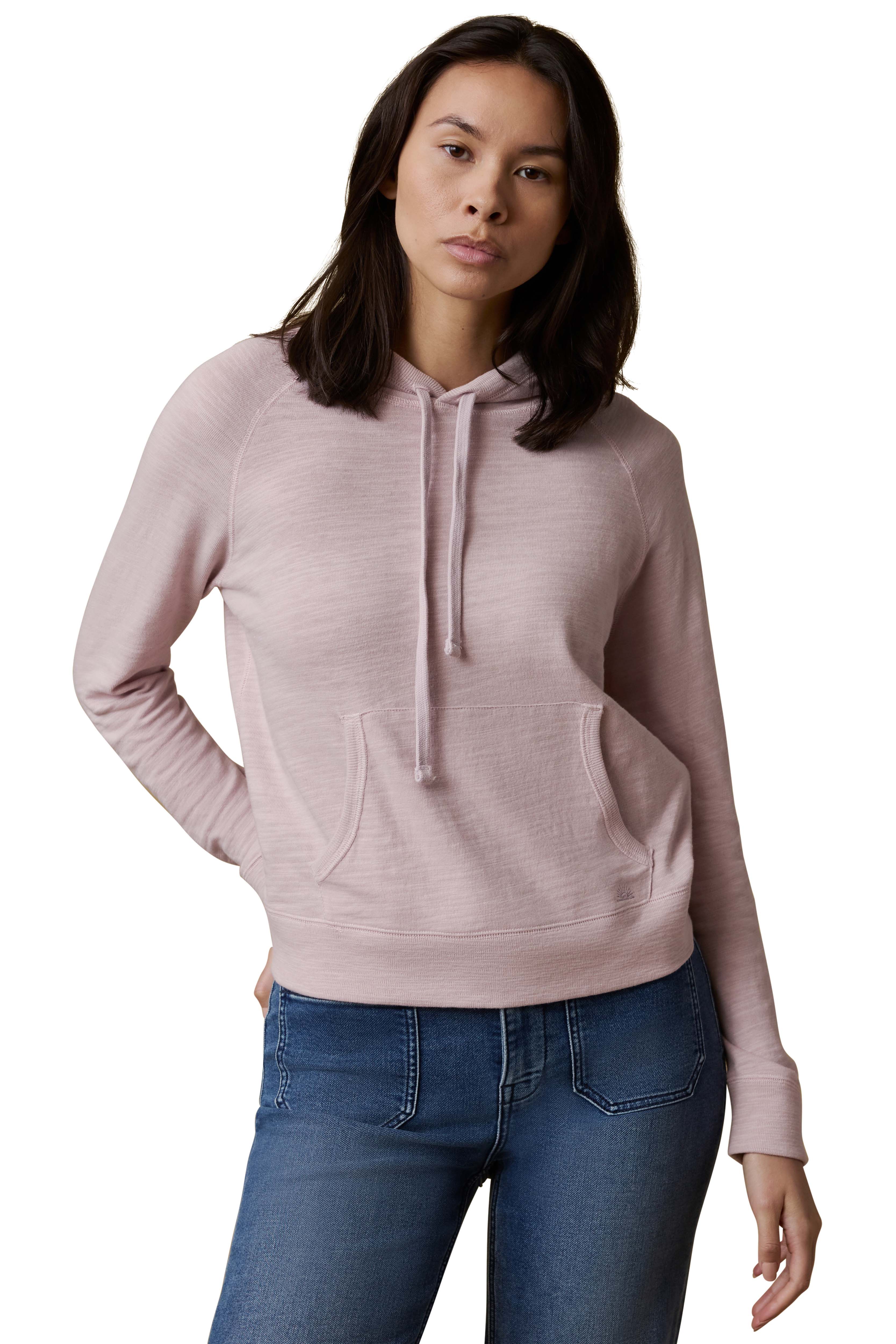 A woman wearing a light purple hoodie and blue jeans