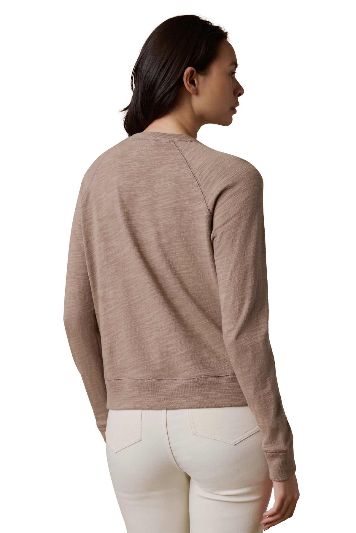 A woman viewed from behind wearing a beige crewneck and white pants, image 3 of 3