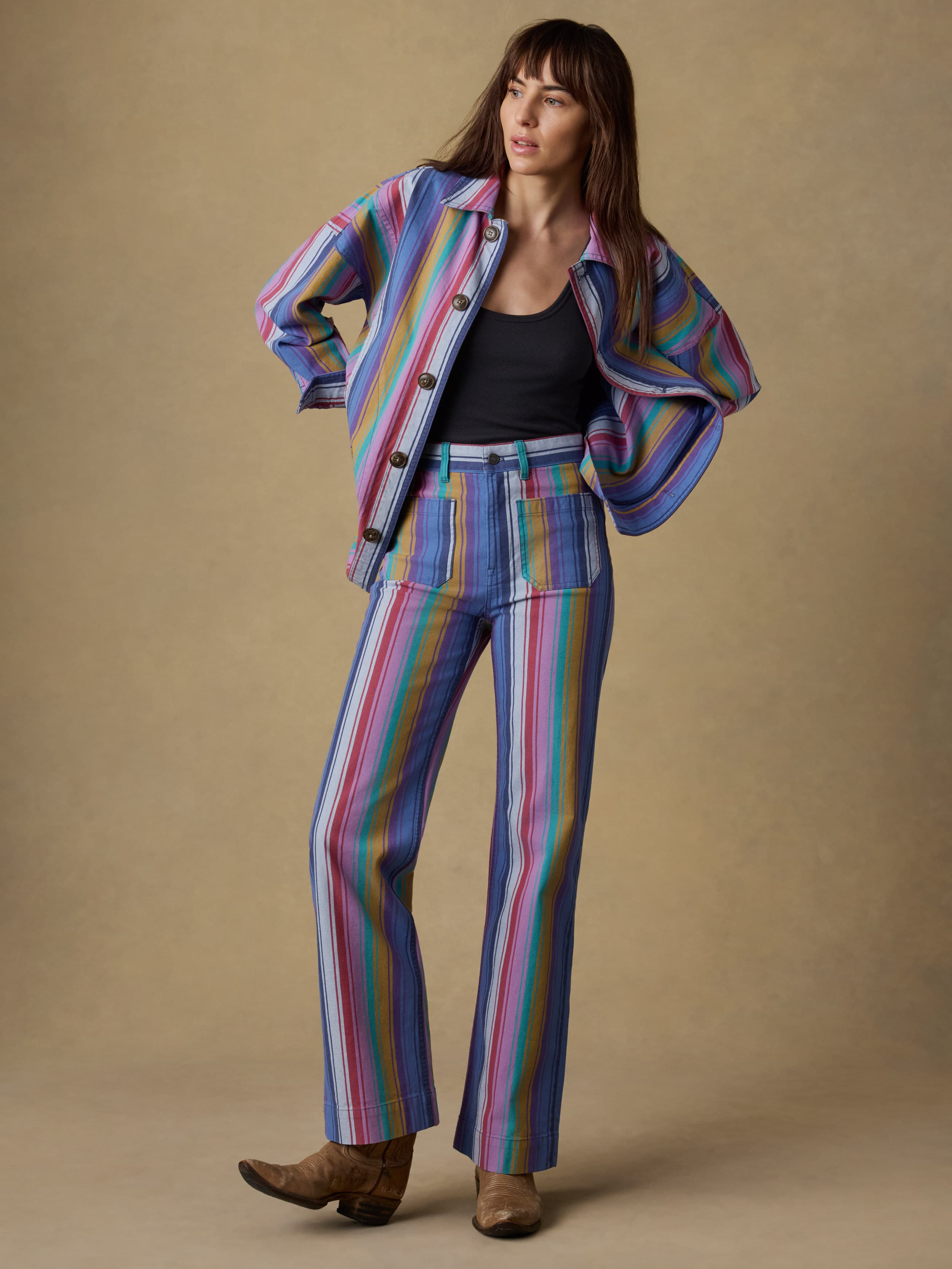 Woman wearing a colorful striped suit against a beige background