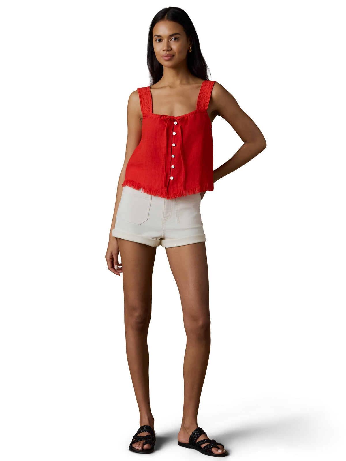 A woman wearing a red tank top and white shorts, image 2 of 5