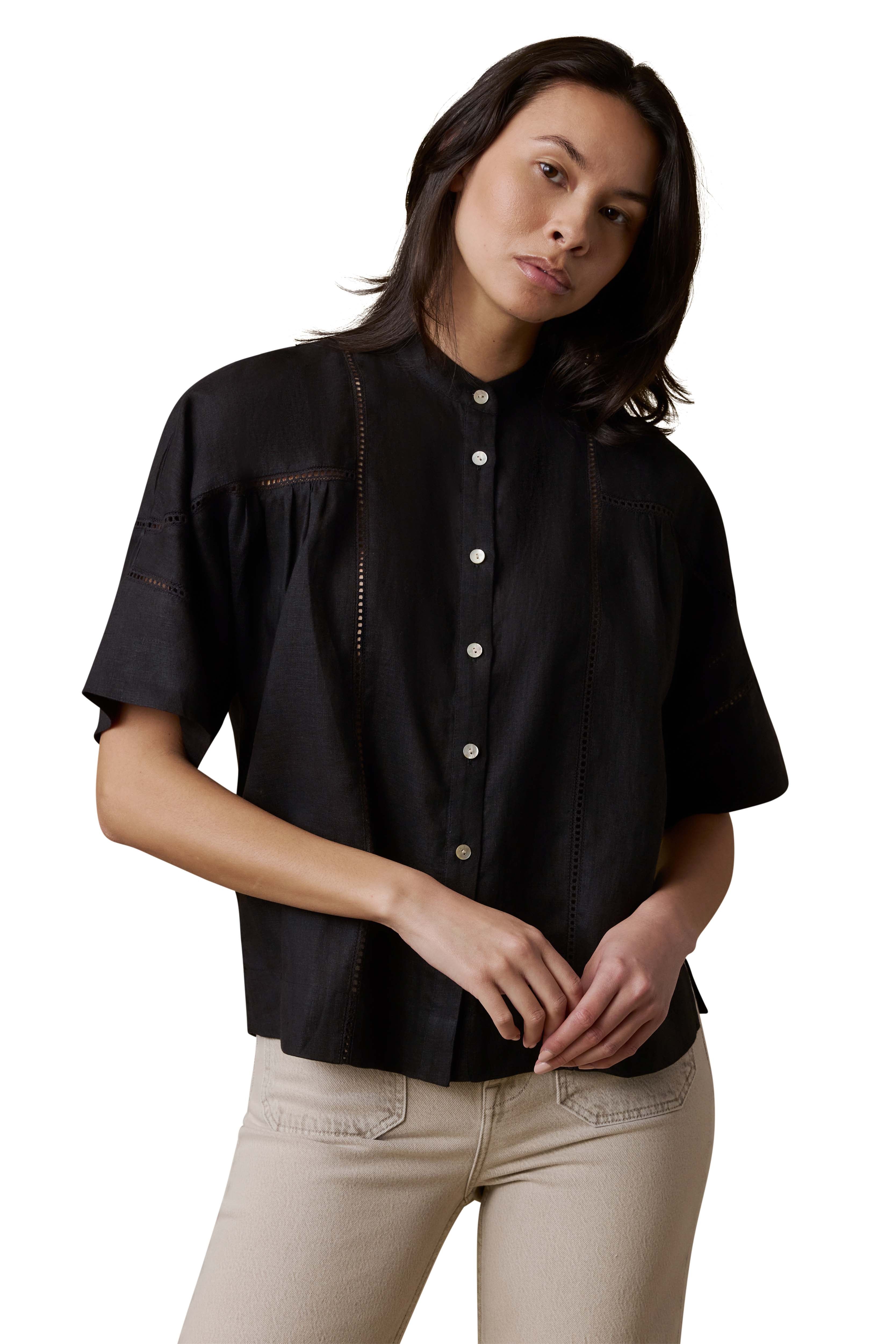 A woman wearing a black shirt and beige pants