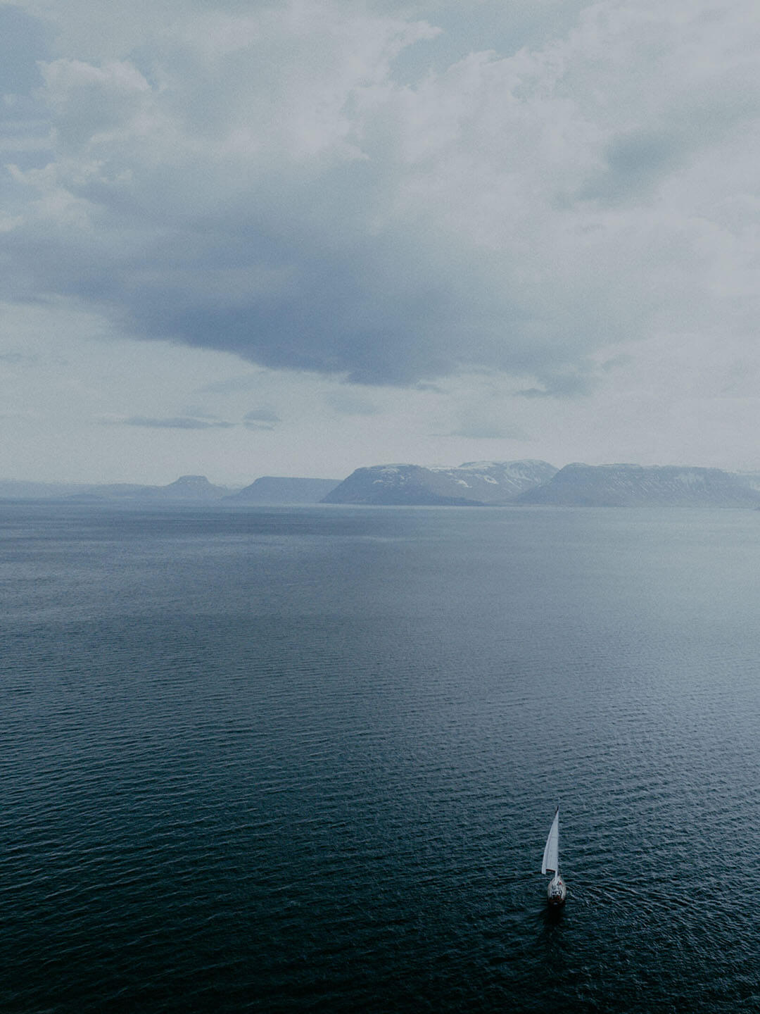 Social and Environmental Impact - An aerial image of a sailboat in the arctic ocean