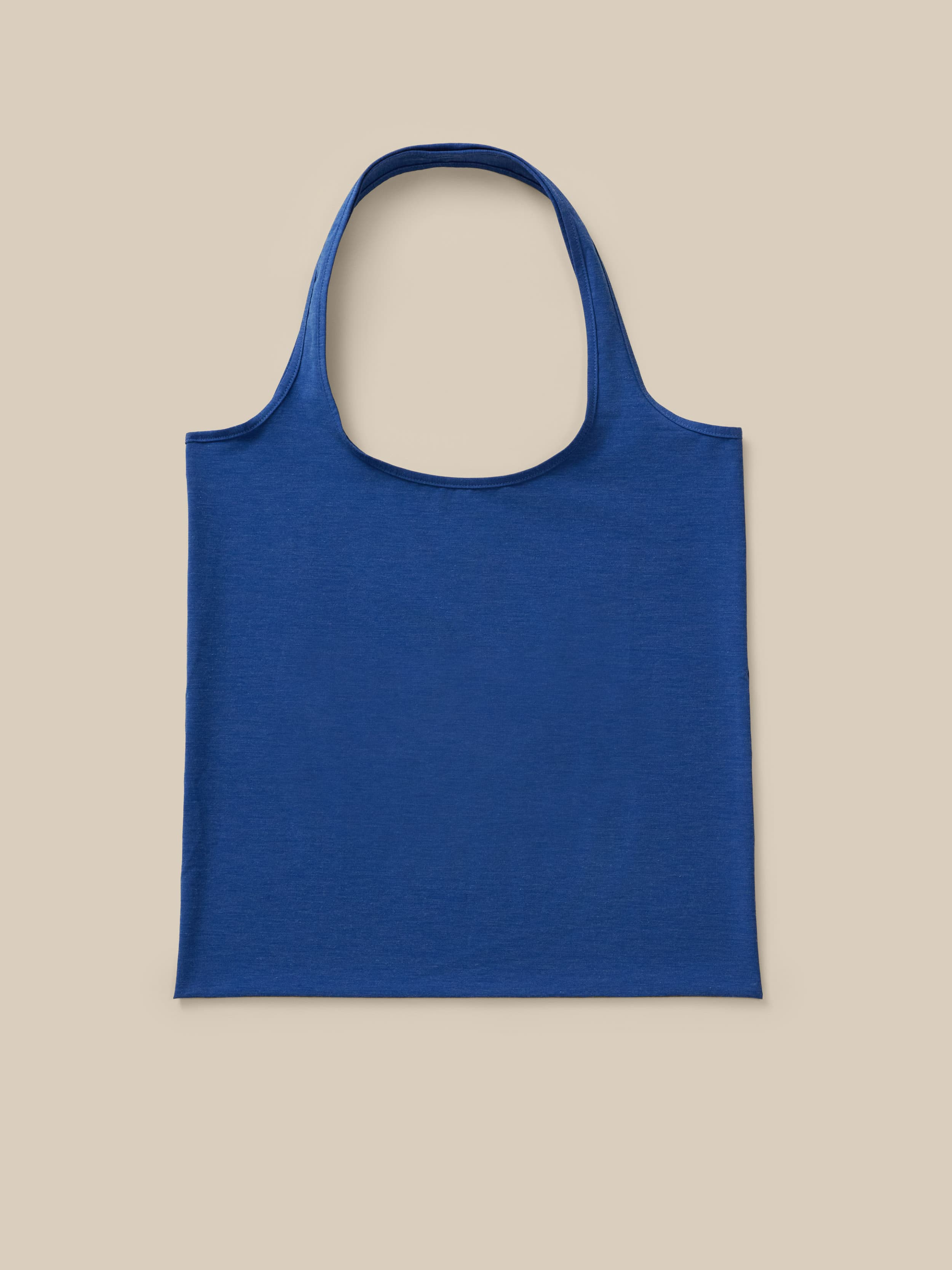 Blue tote bag against a neutral background