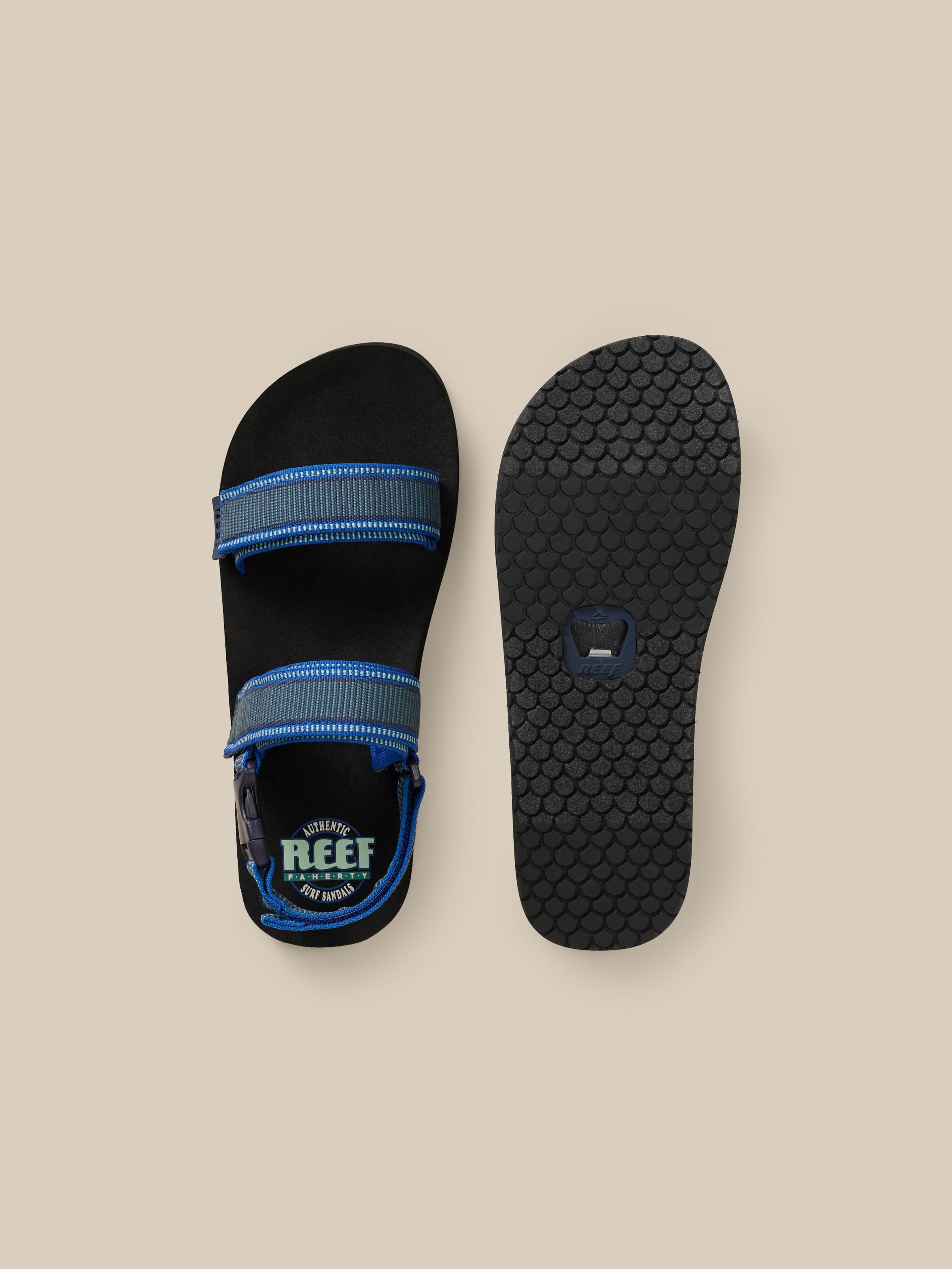 Black sandal with blue accents on a beige background