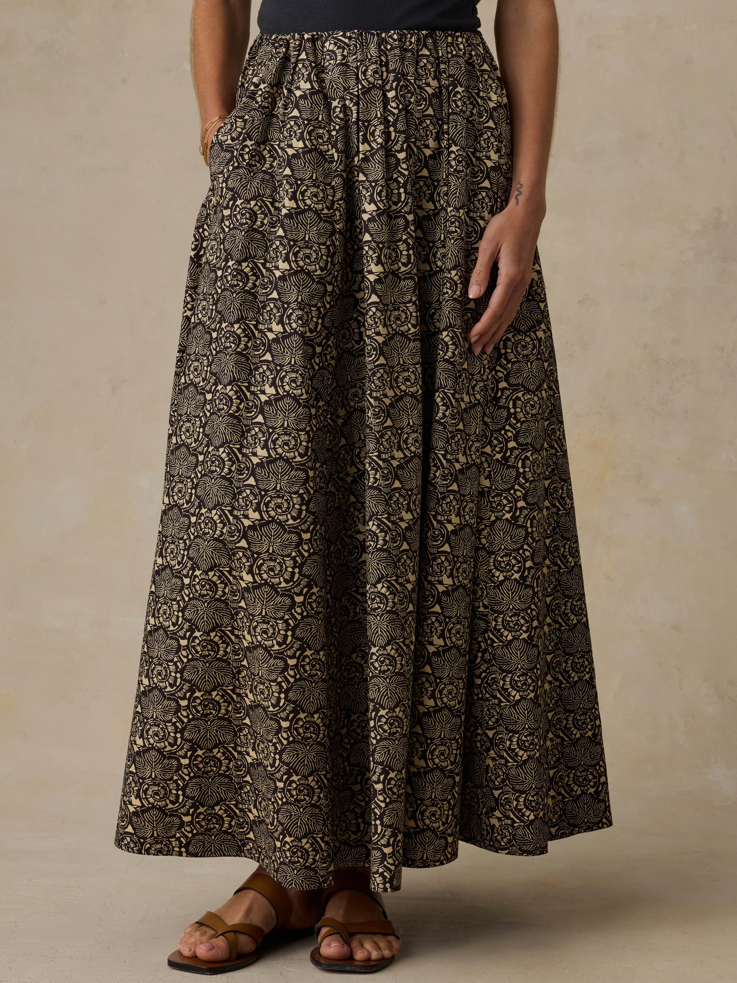 Woman wearing a floral patterned skirt against a beige background
