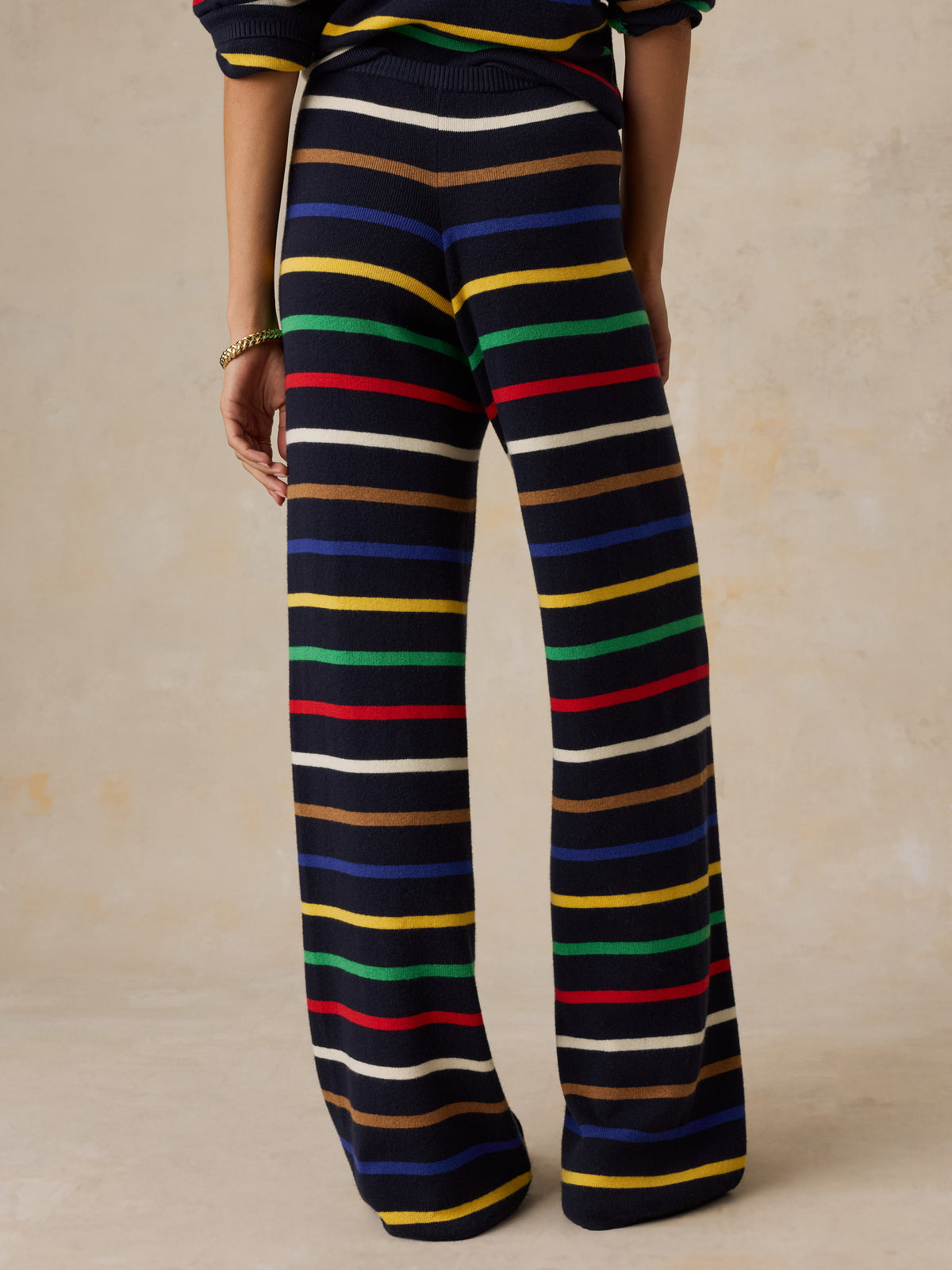 A woman viewed from behind wearing a striped set, image 3 of 6