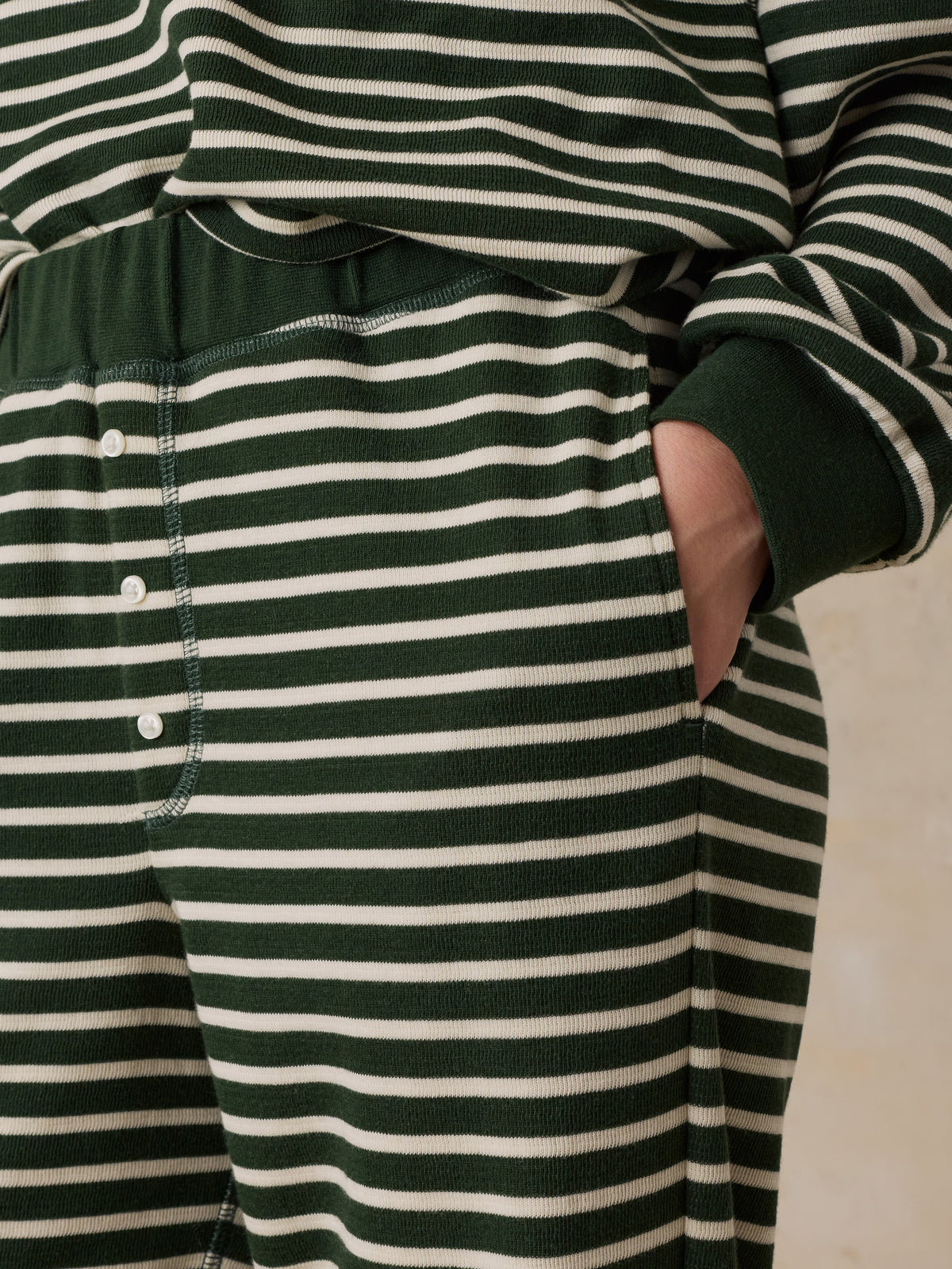 Close up of a woman wearing a green striped pajama set, image 5 of 6