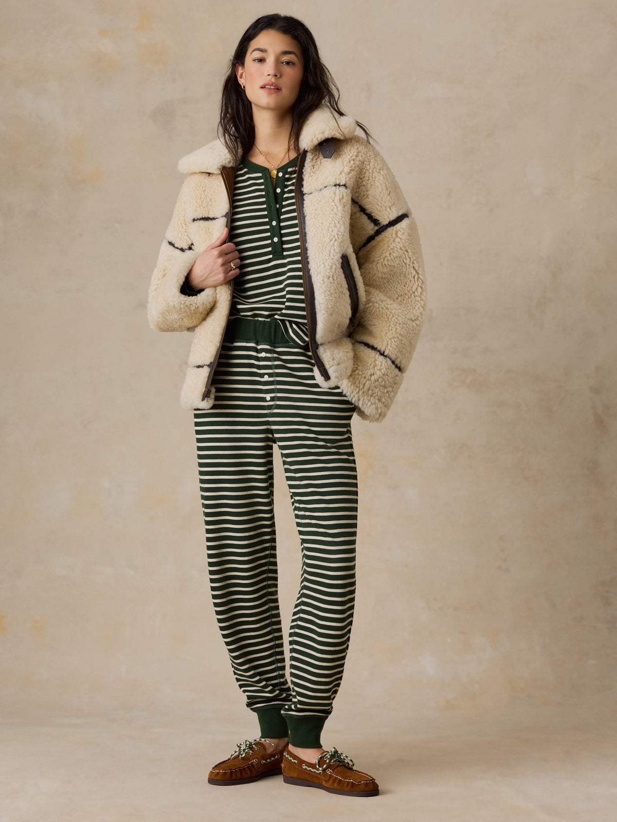 A woman wearing a green striped pajama pant and shearling jacket, image 3 of 6