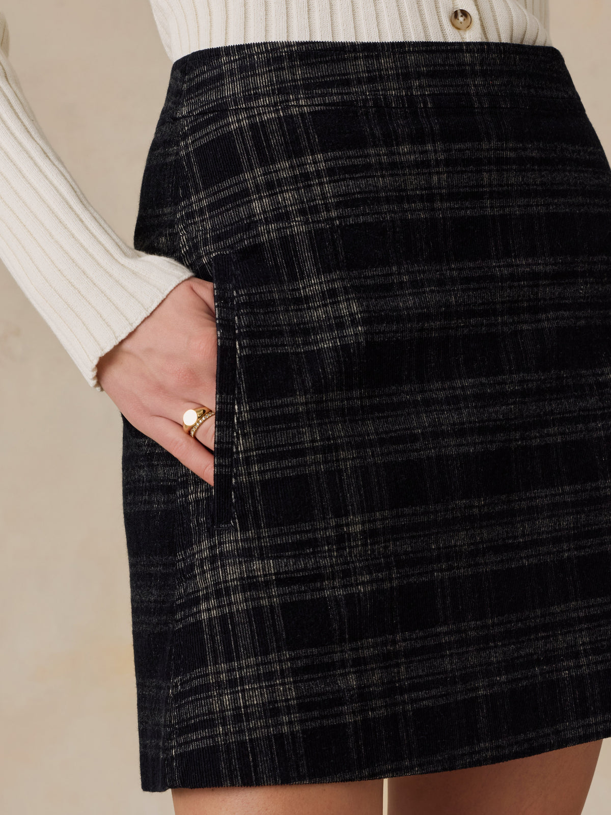 Close up of a woman wearing a white top and plaid mini skirt, image 4 of 6