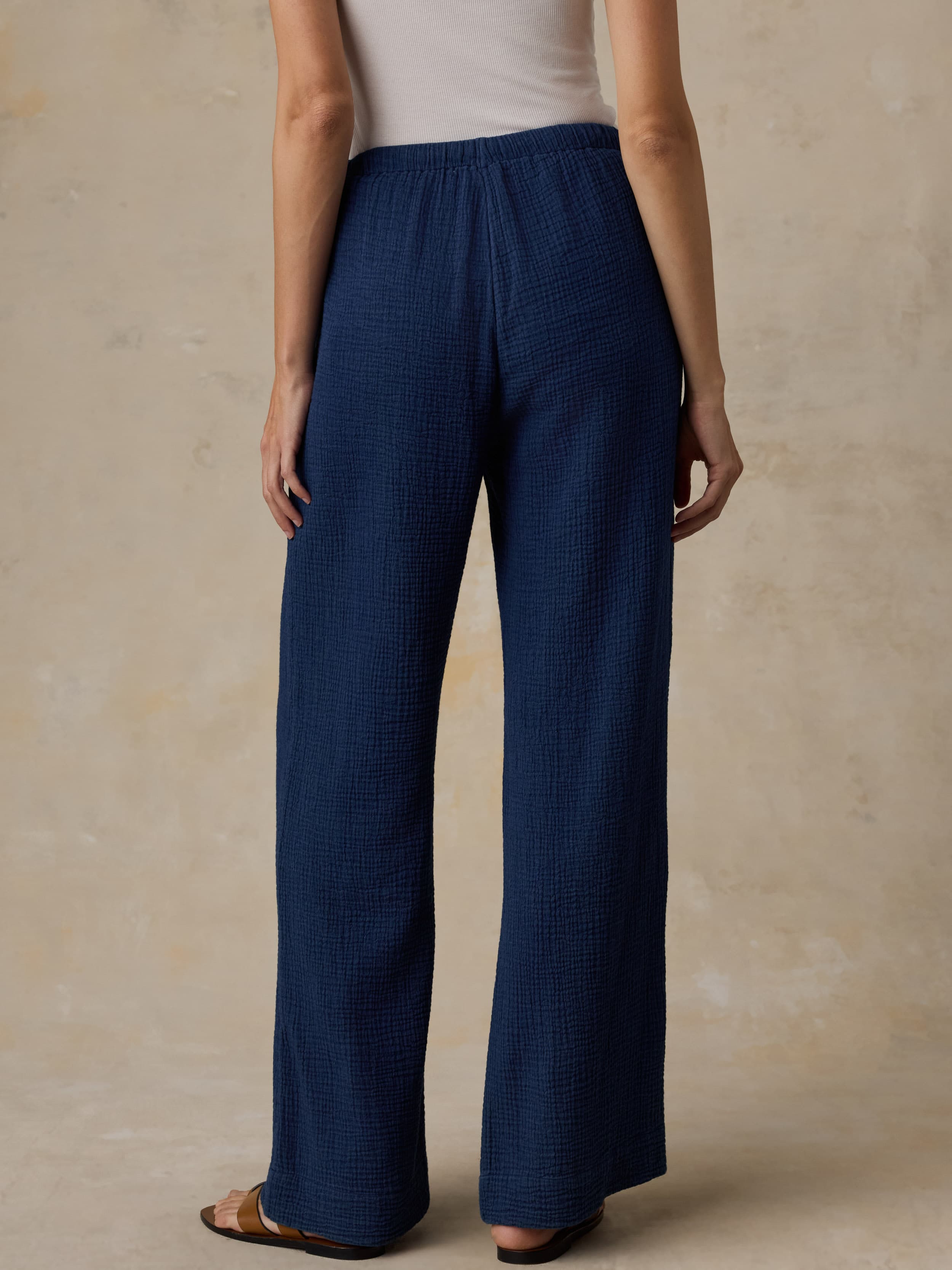 Woman wearing blue pants against a beige background