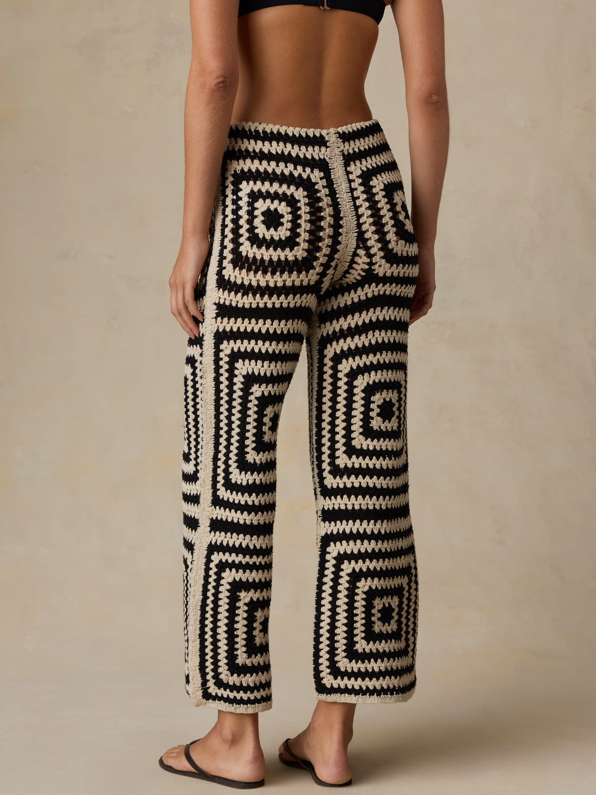 Woman wearing black and white patterned pants on a beige background, image 5 of 5