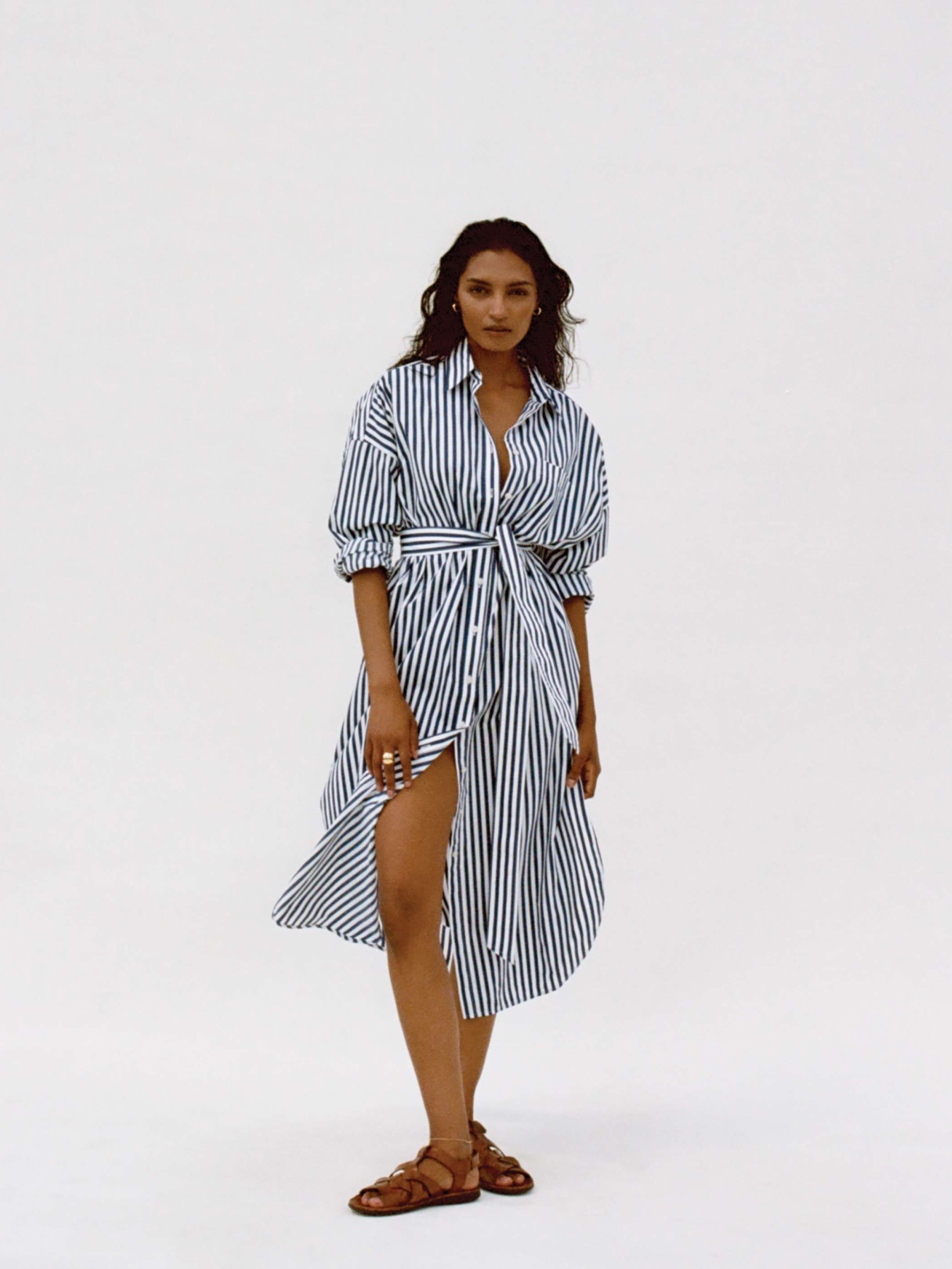 Woman wearing a blue and white striped dress against a white background
