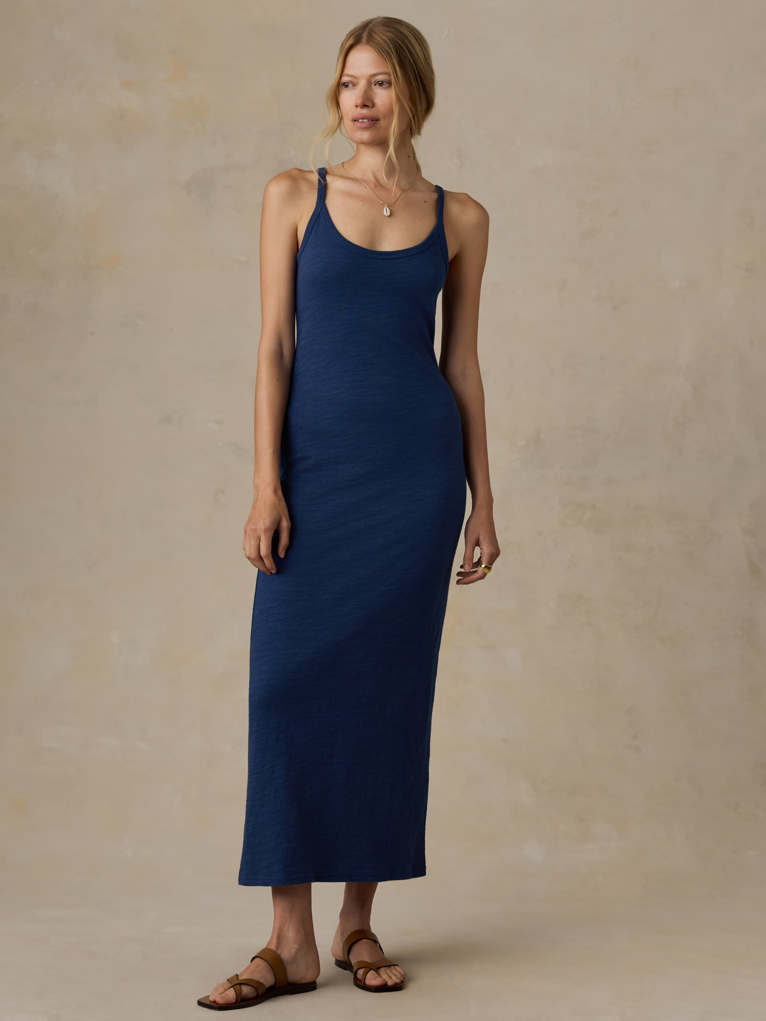 Woman wearing a blue tank dress against a beige background