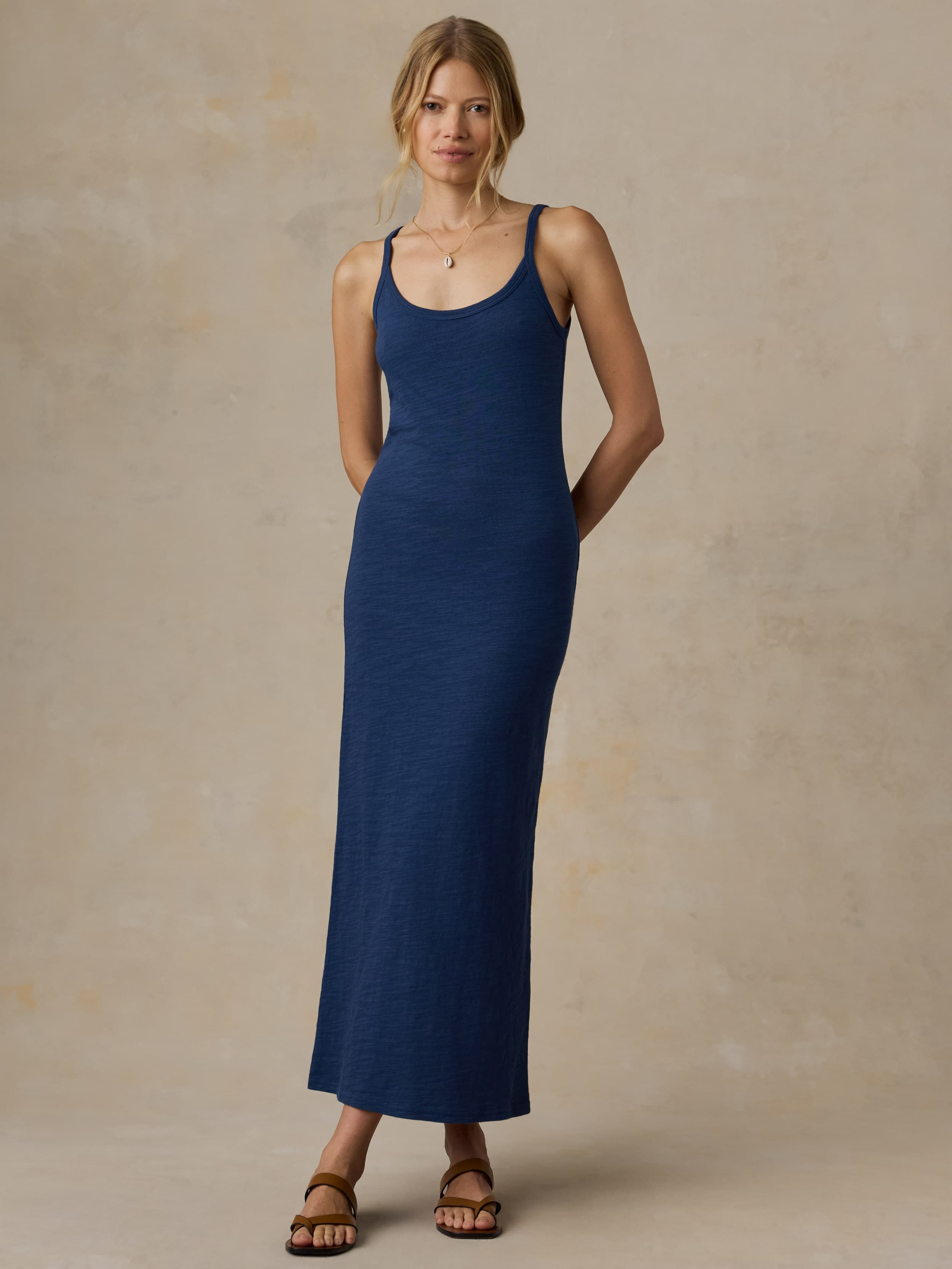 Woman wearing a blue tank dress against a beige background