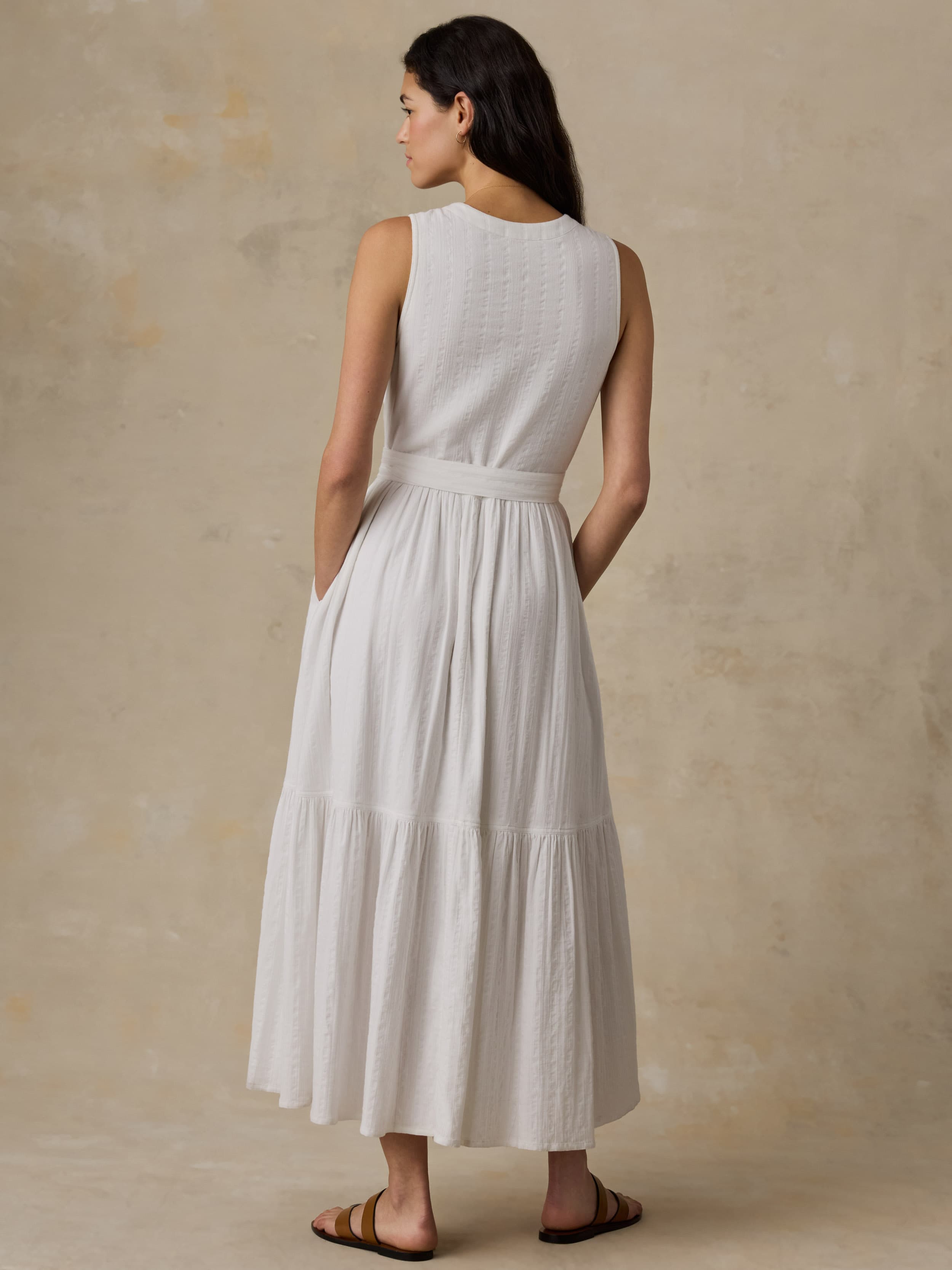 Woman wearing a white dress against a beige background