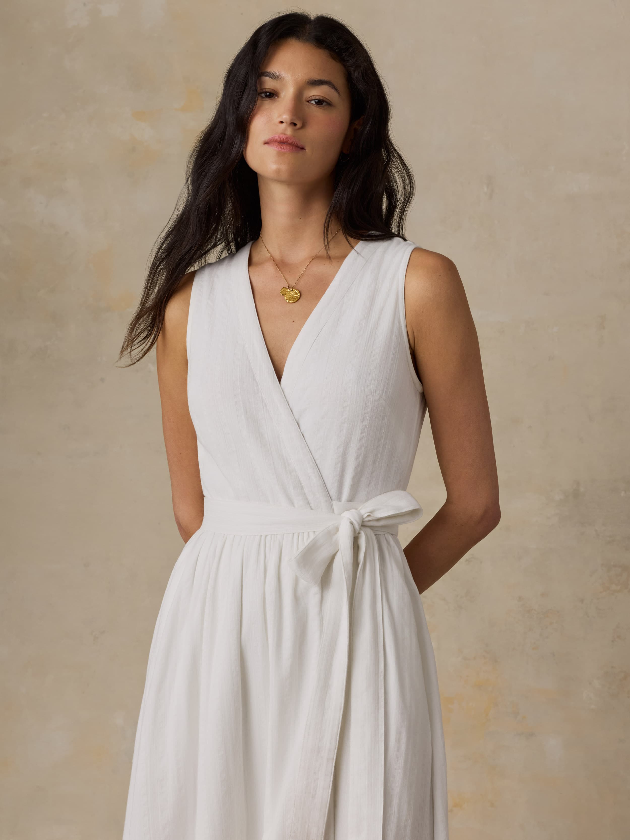 Woman wearing a white dress against a beige background