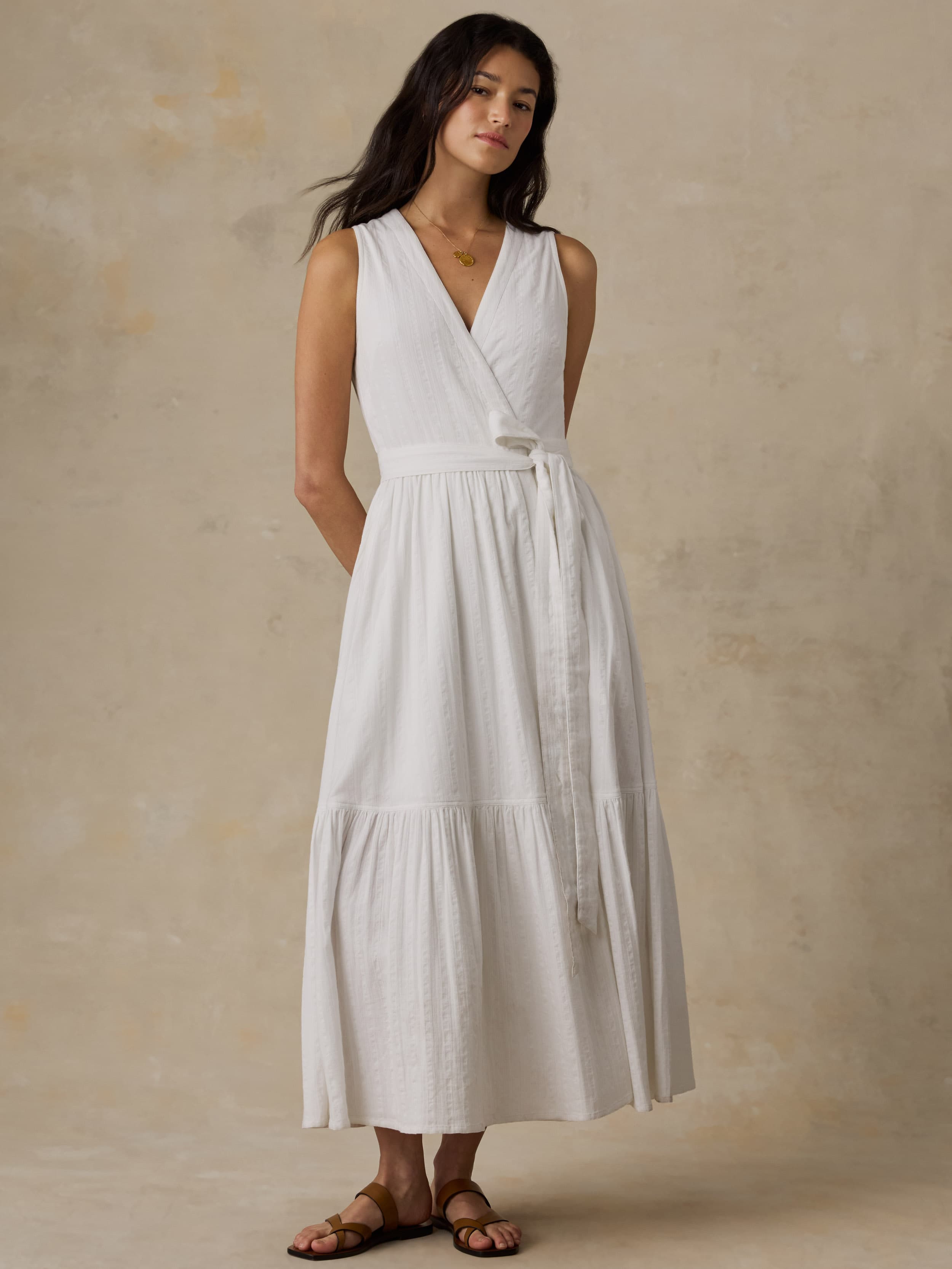 Woman wearing a white dress against a beige background