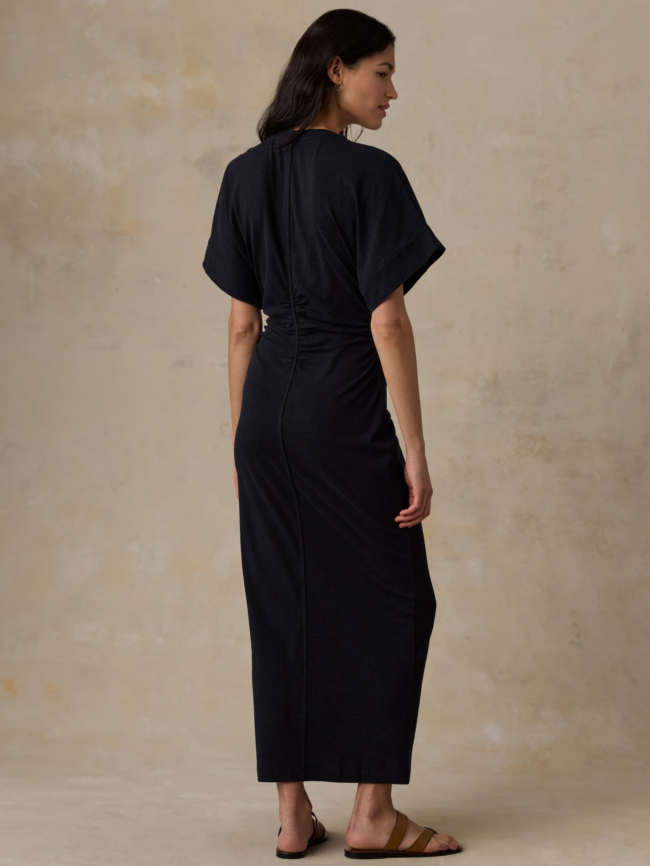 Woman wearing a black dress against a beige background