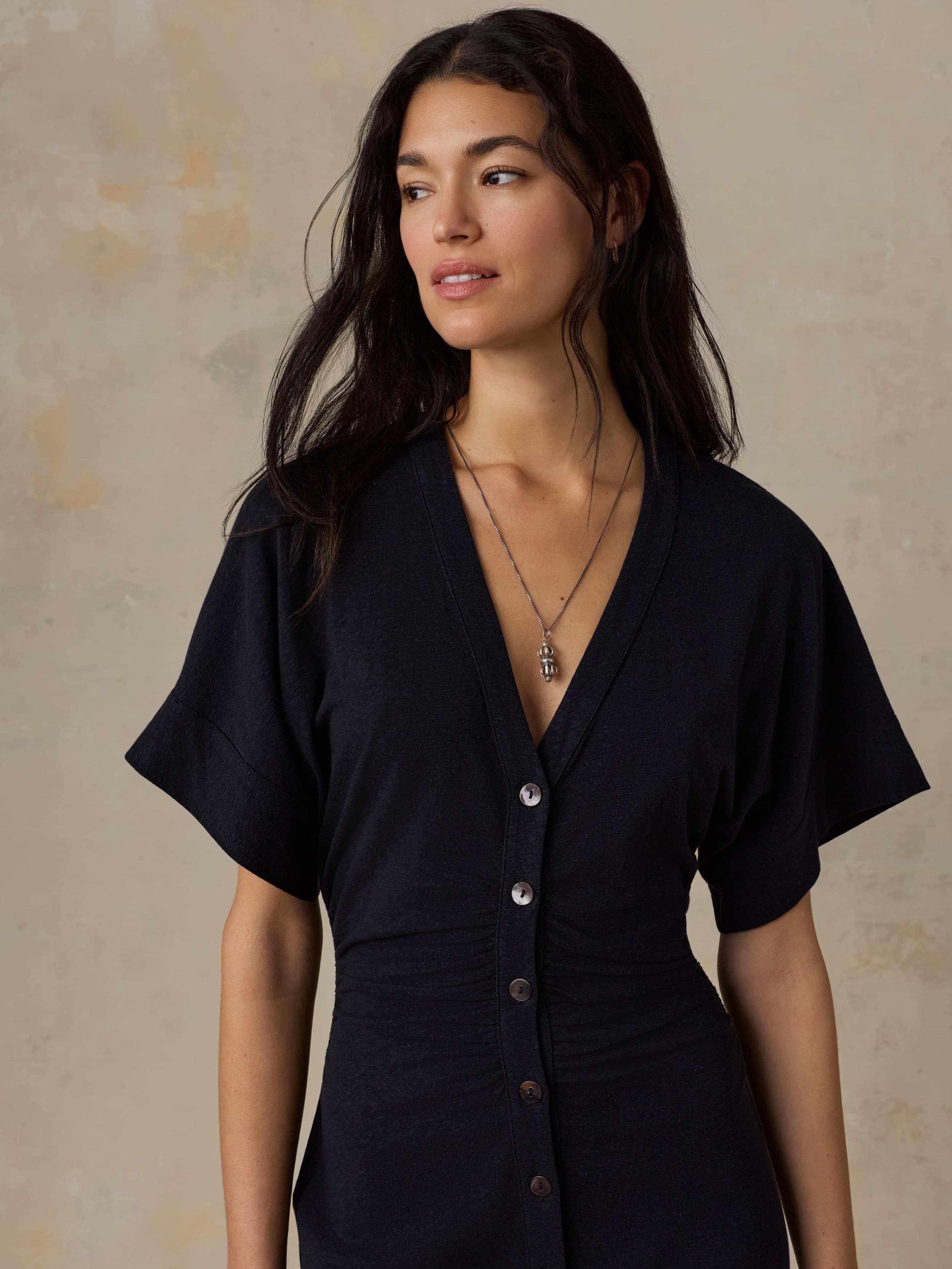Woman wearing a black dress with a neutral background