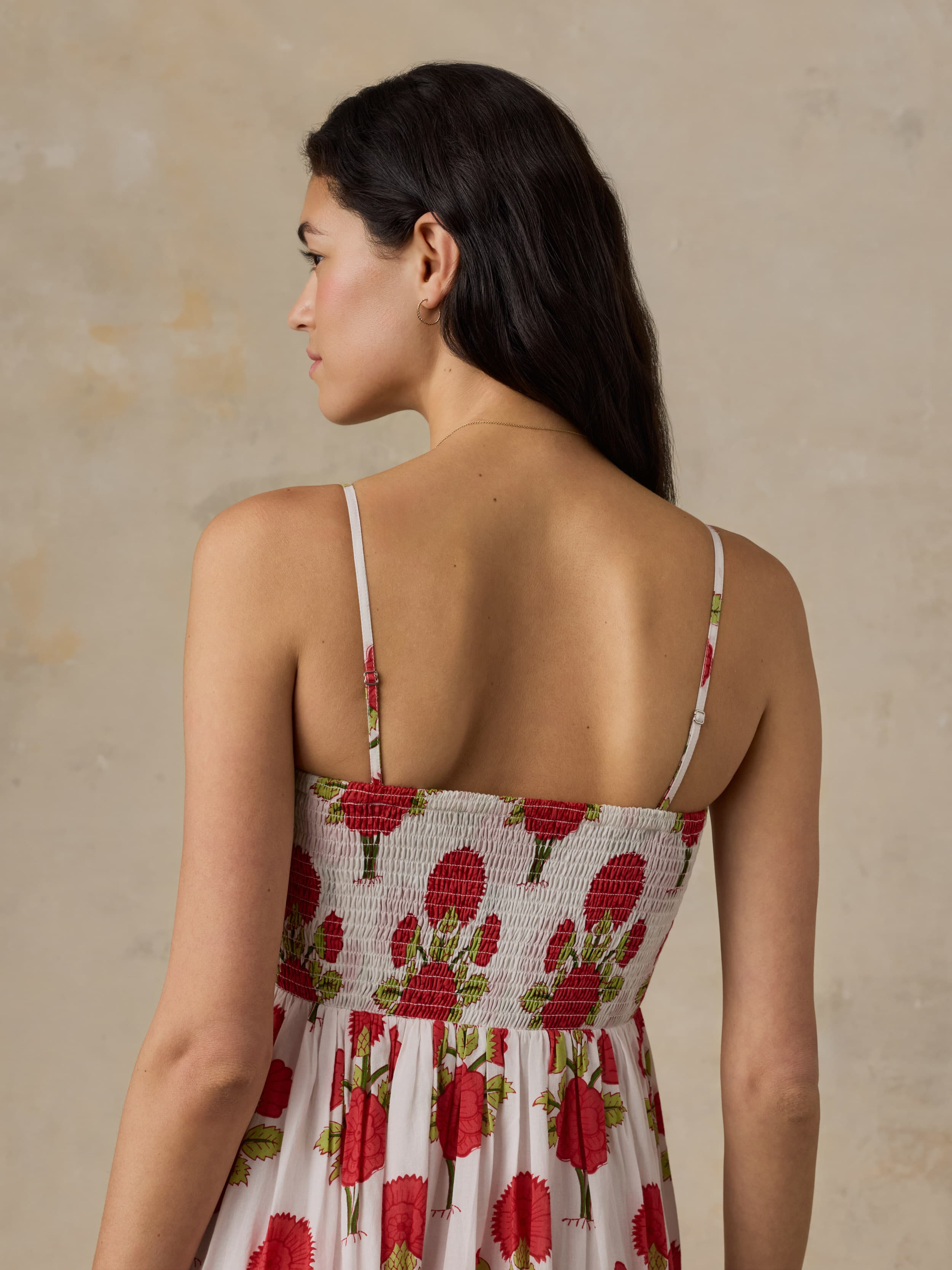 Woman wearing a floral dress with a beige background