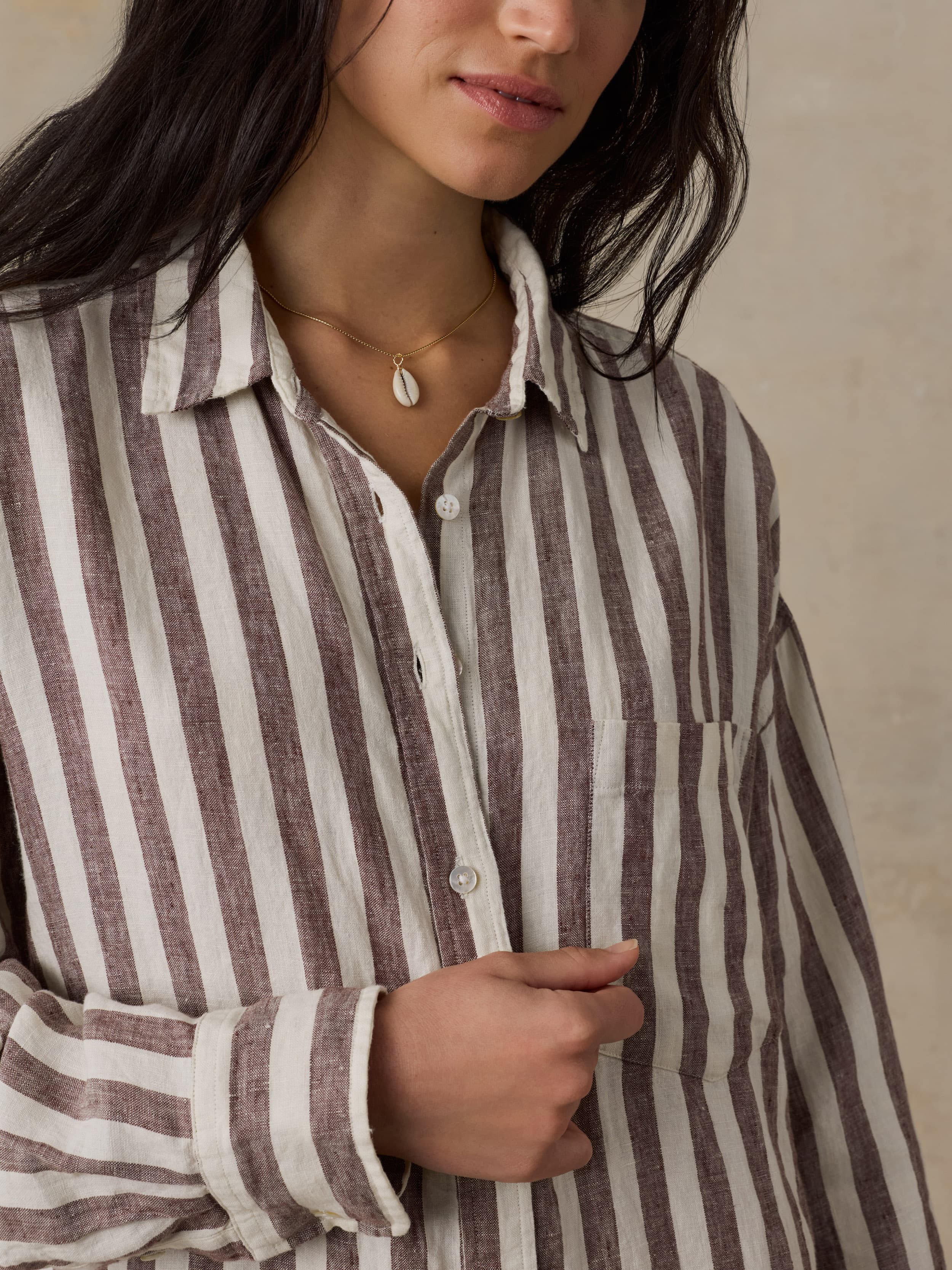 Woman wearing a striped shirt dress with a neutral background