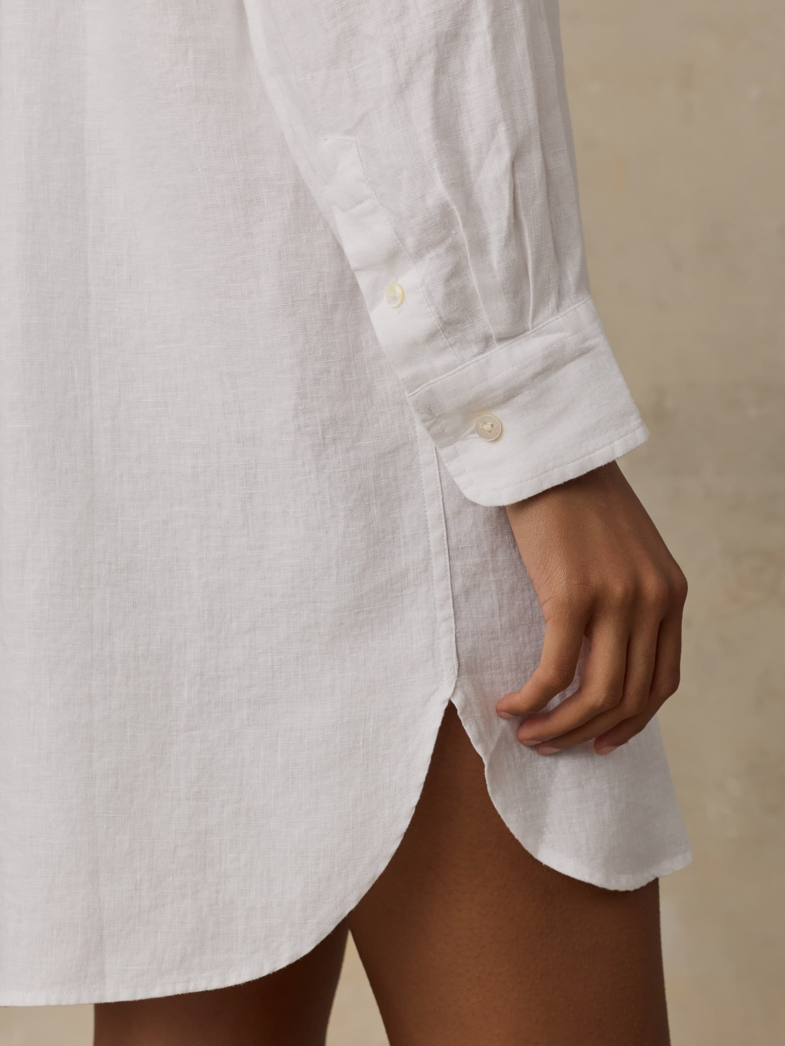 White shirtdress worn by a woman with a neutral background