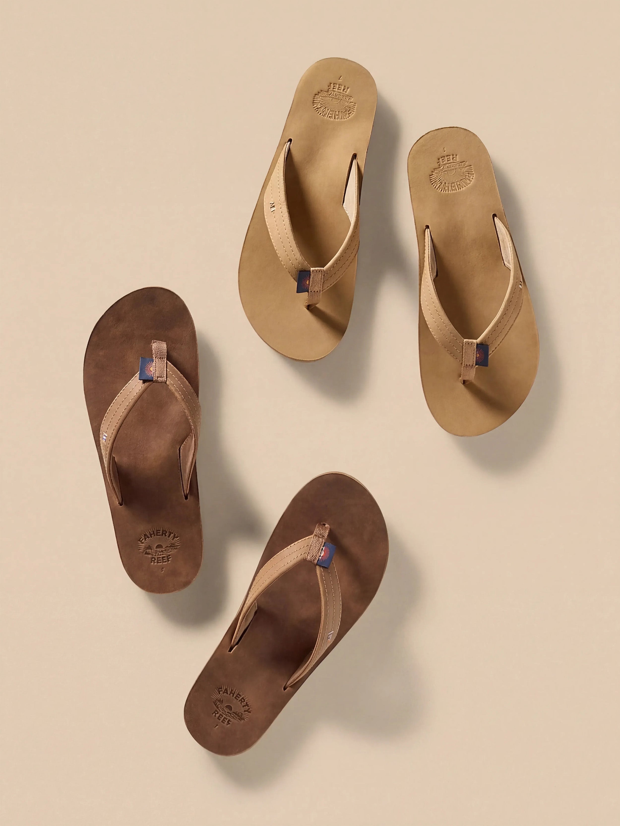 Two pairs of brown sandals on a beige background